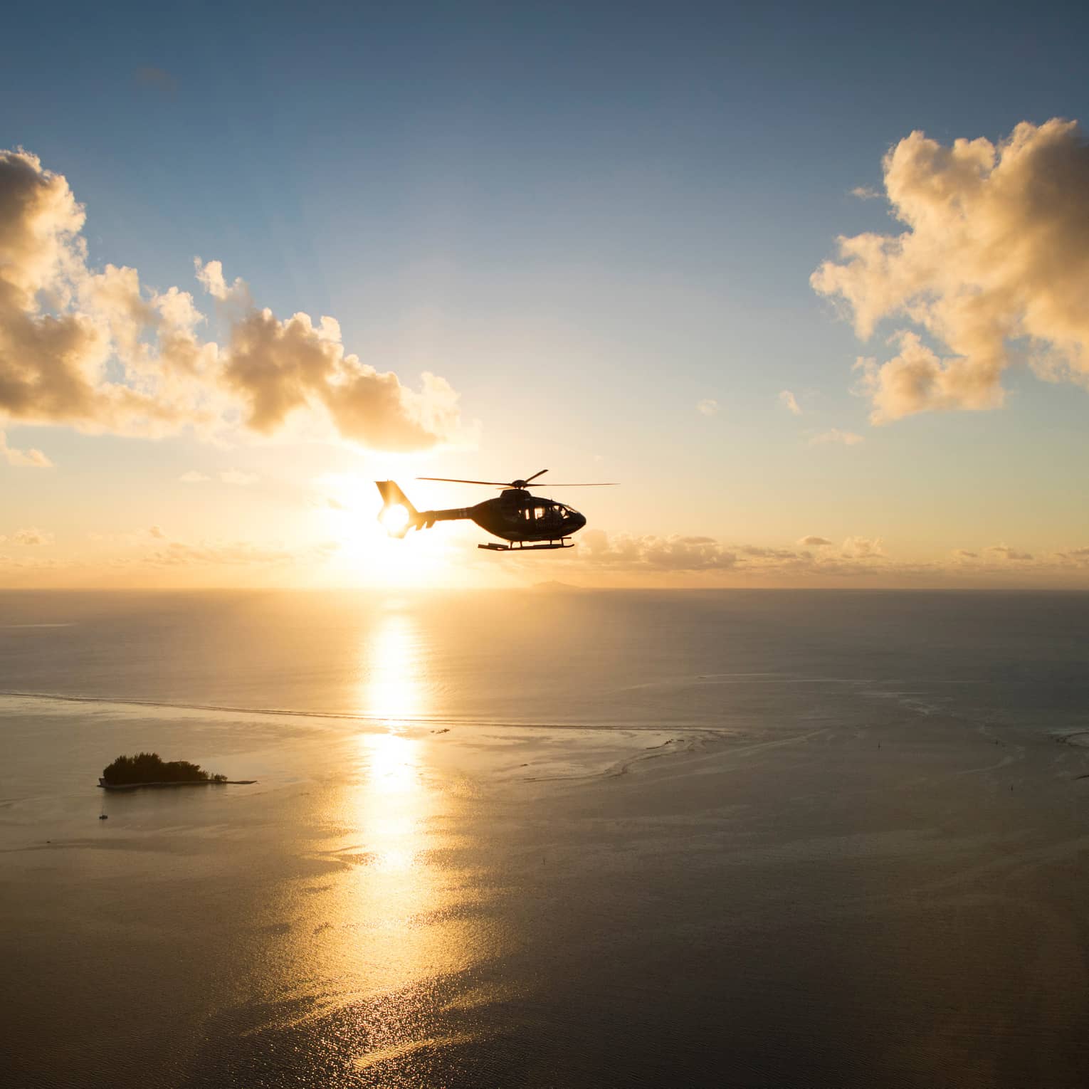 Helicopter over the sea at sunset