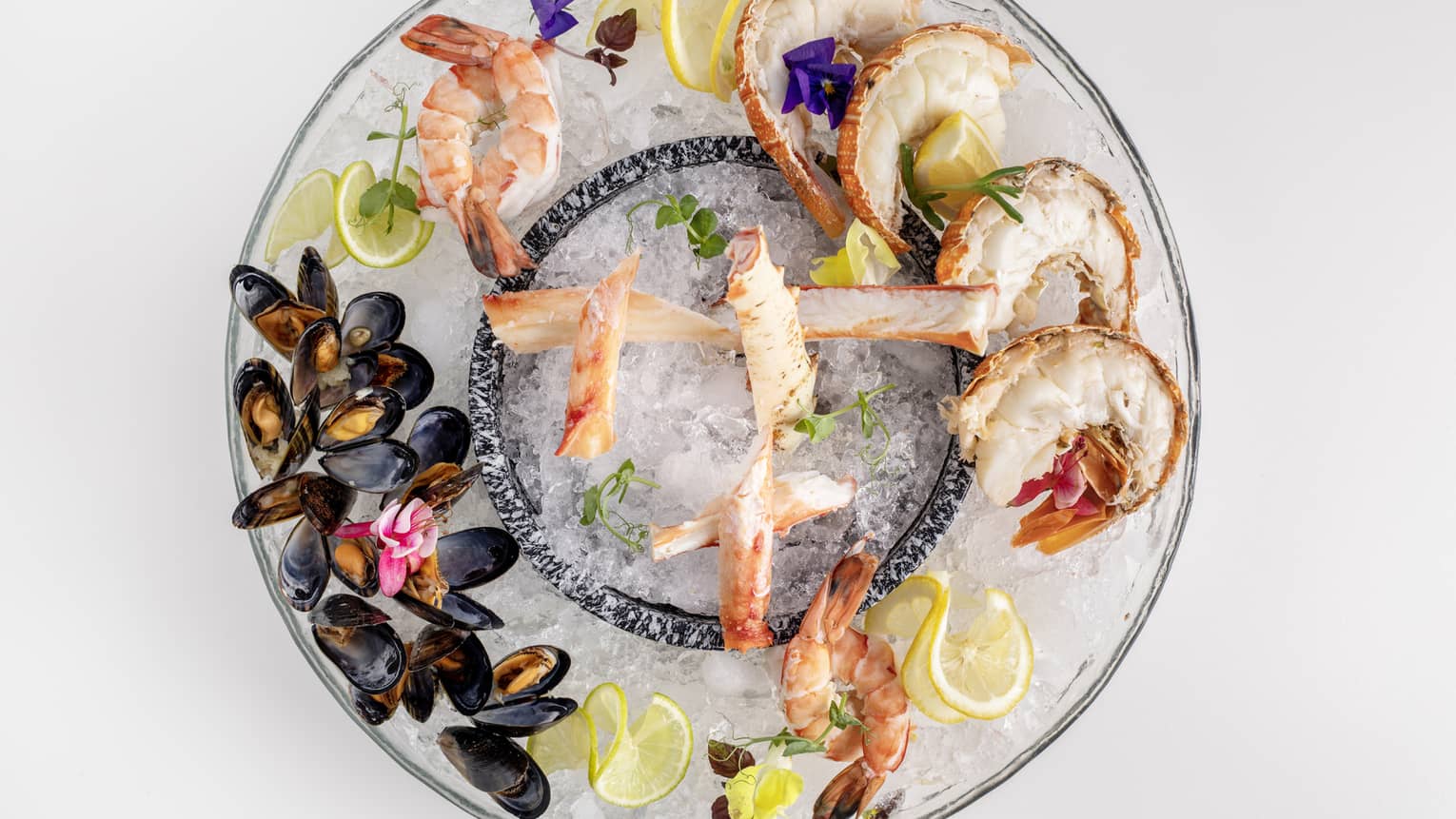  Makani Seafood Platter featuring king crab, lobster, prawns and mussels garnished with lemon slices and flowers