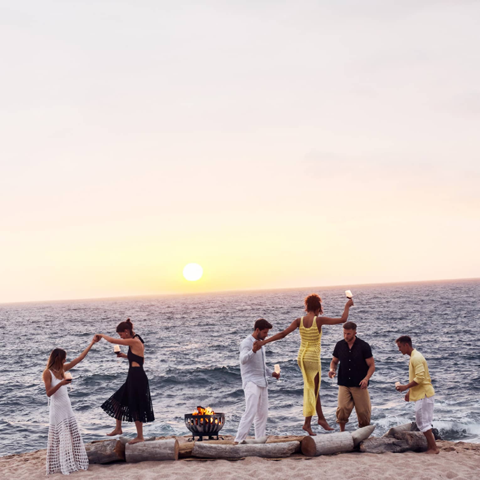 A group of people dancing on a beach.