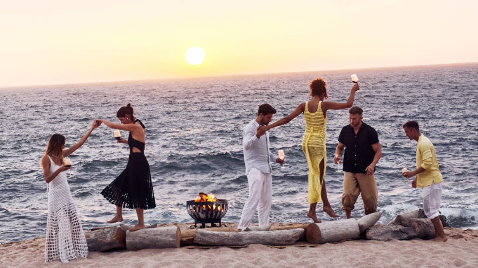 A group of people dancing on a beach.