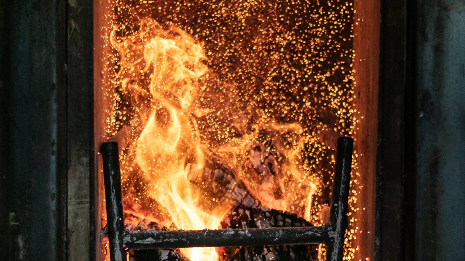 A fire roasting several pieces of wood. 