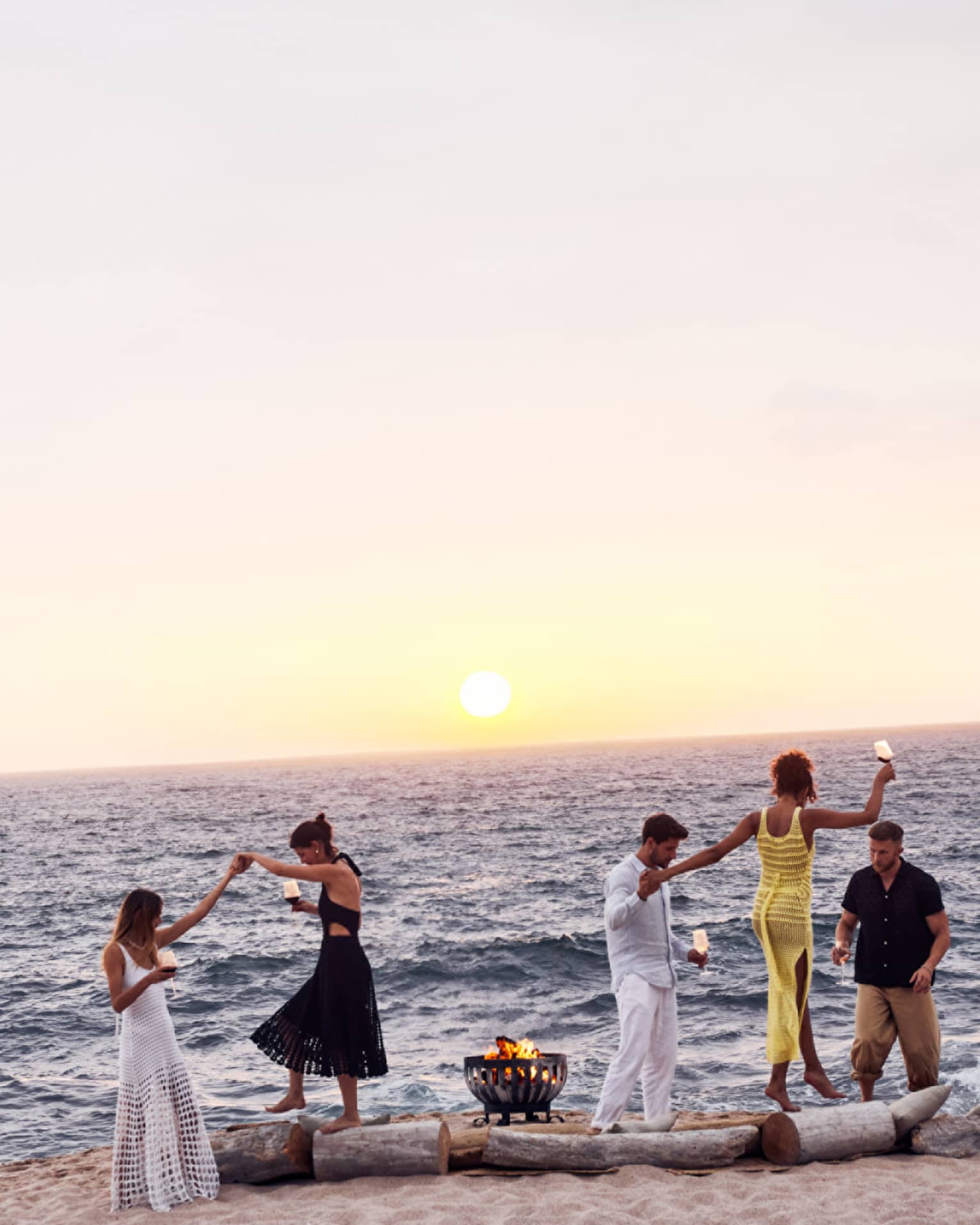 A group of people dancing on a beach.