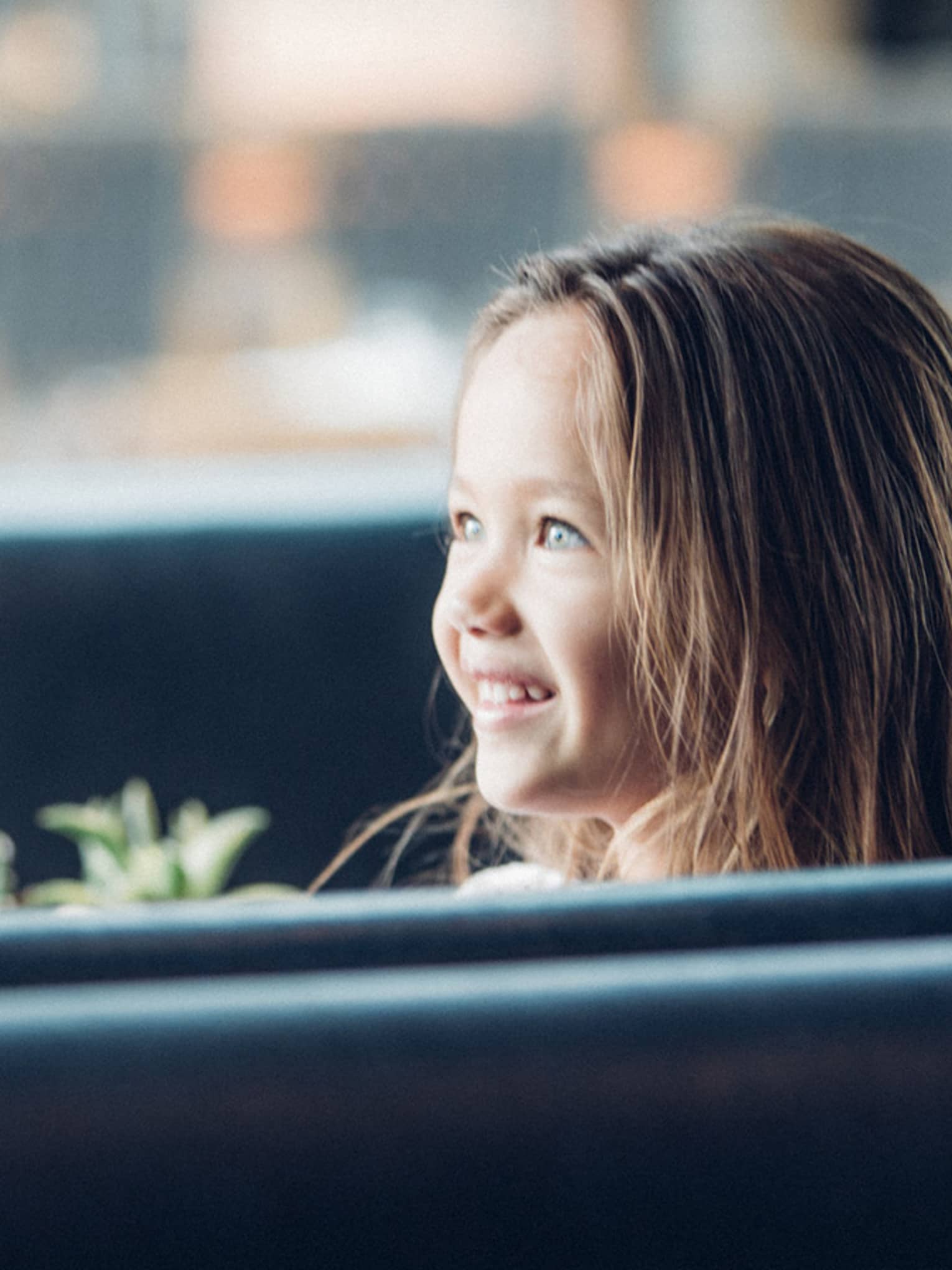 Woman in booth faces smiling, wide-eyed young girl