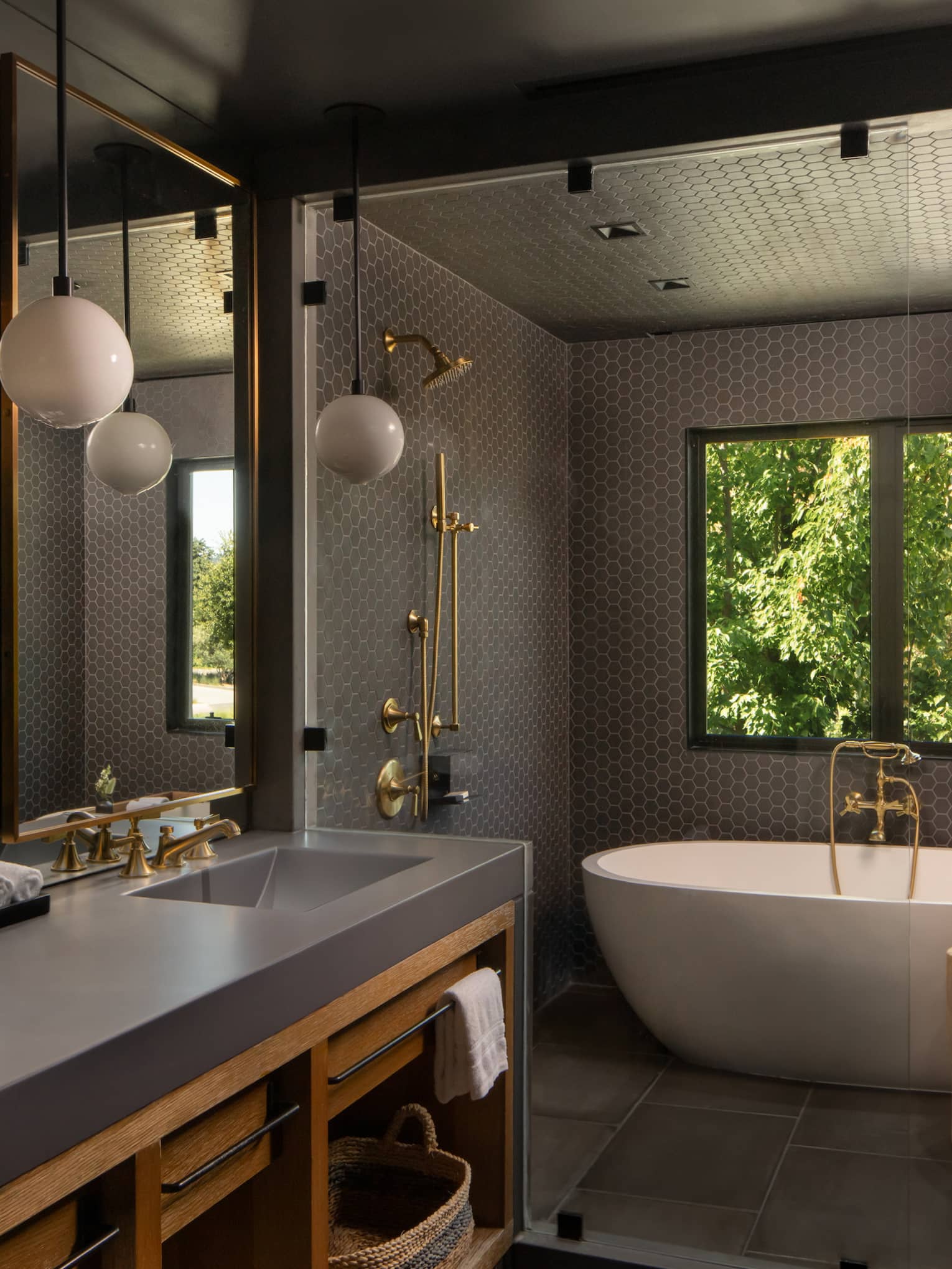 Contemporary bathroom featuring double vanity, standalone tub and dark grey walls