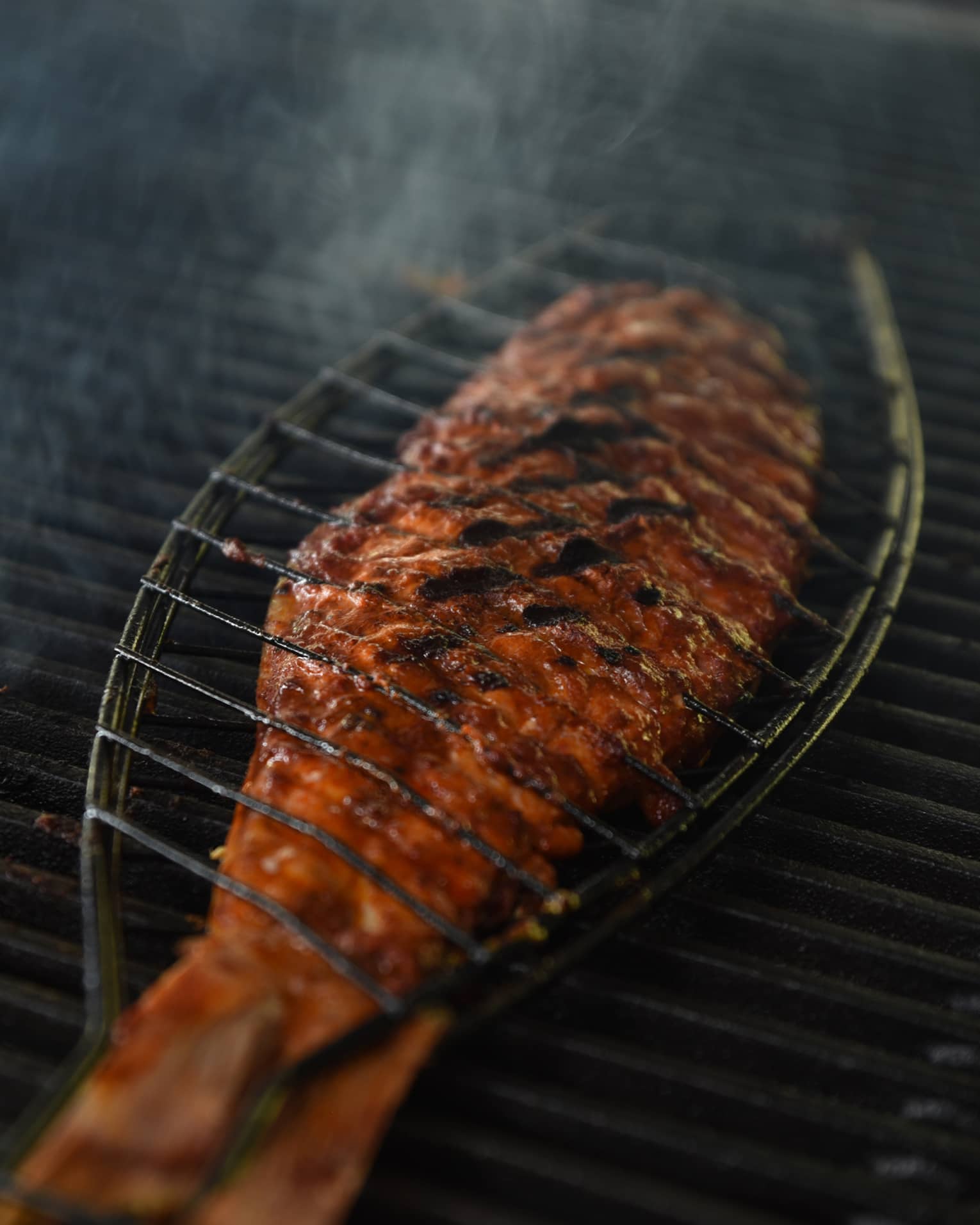 A fish cooking on a grill.