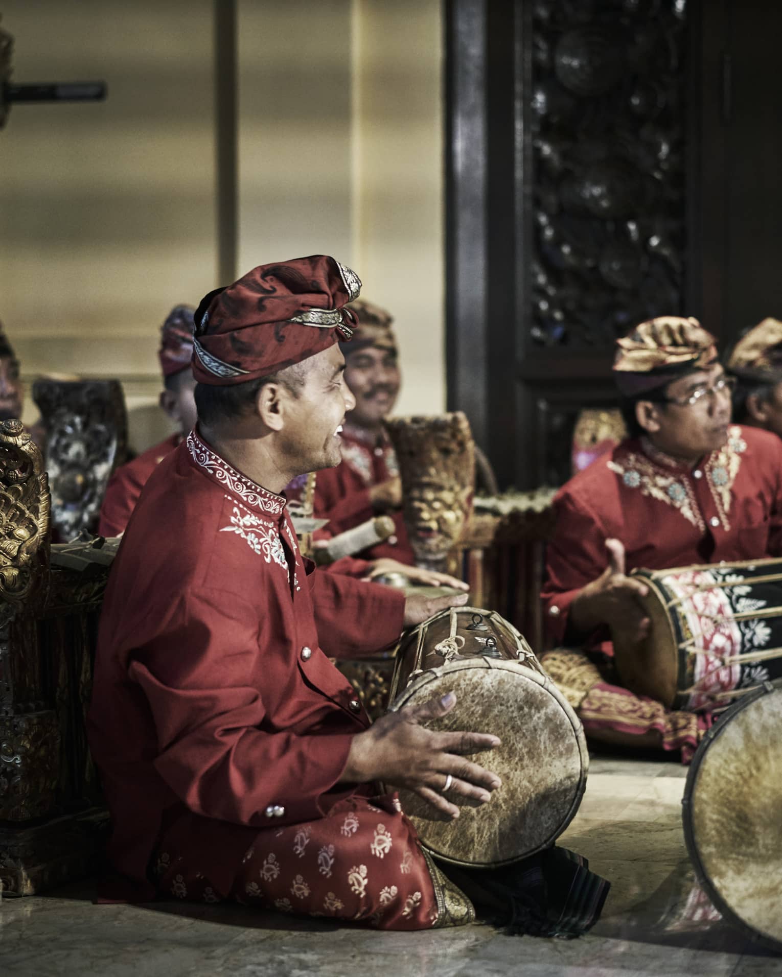 Smiling musical band sits cross legged with hand drums