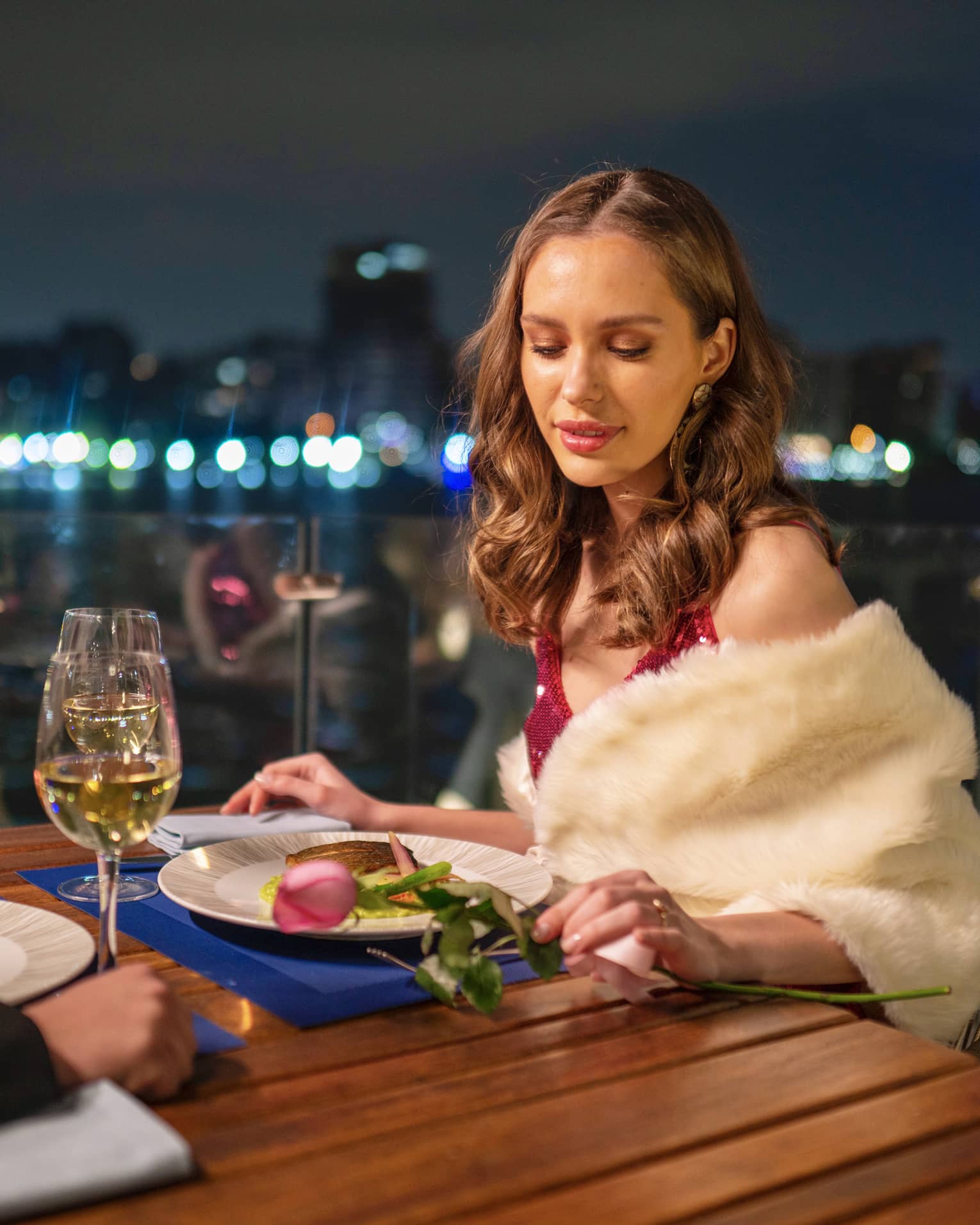 Woman enjoys meal outdoors, downtown Cairo visible in background