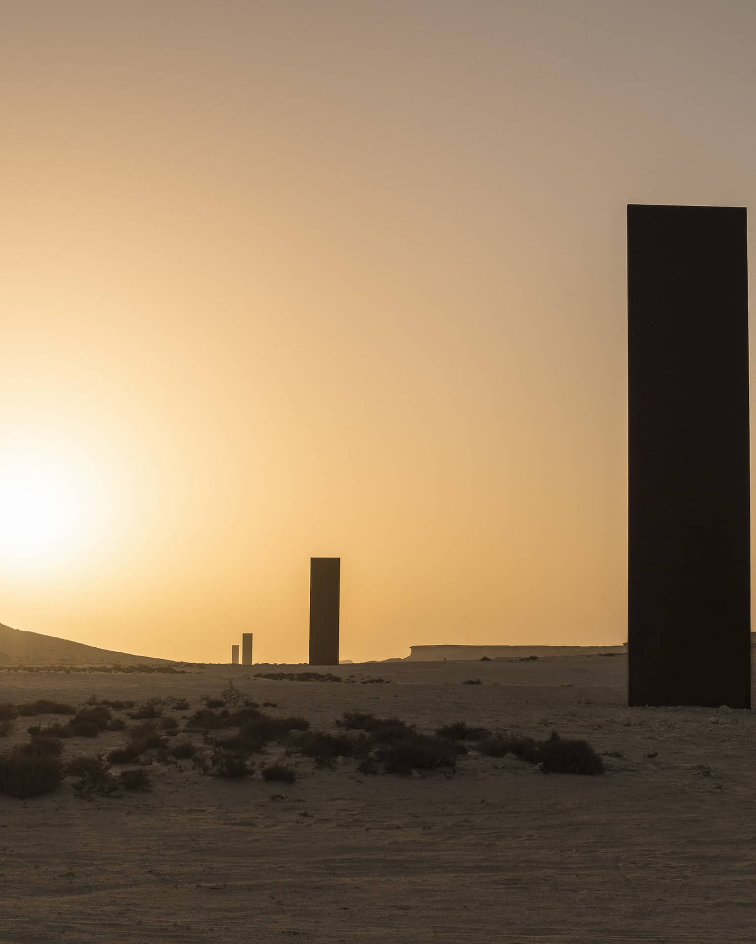 Silhouettes of Richard Serra Sculpture against sunset