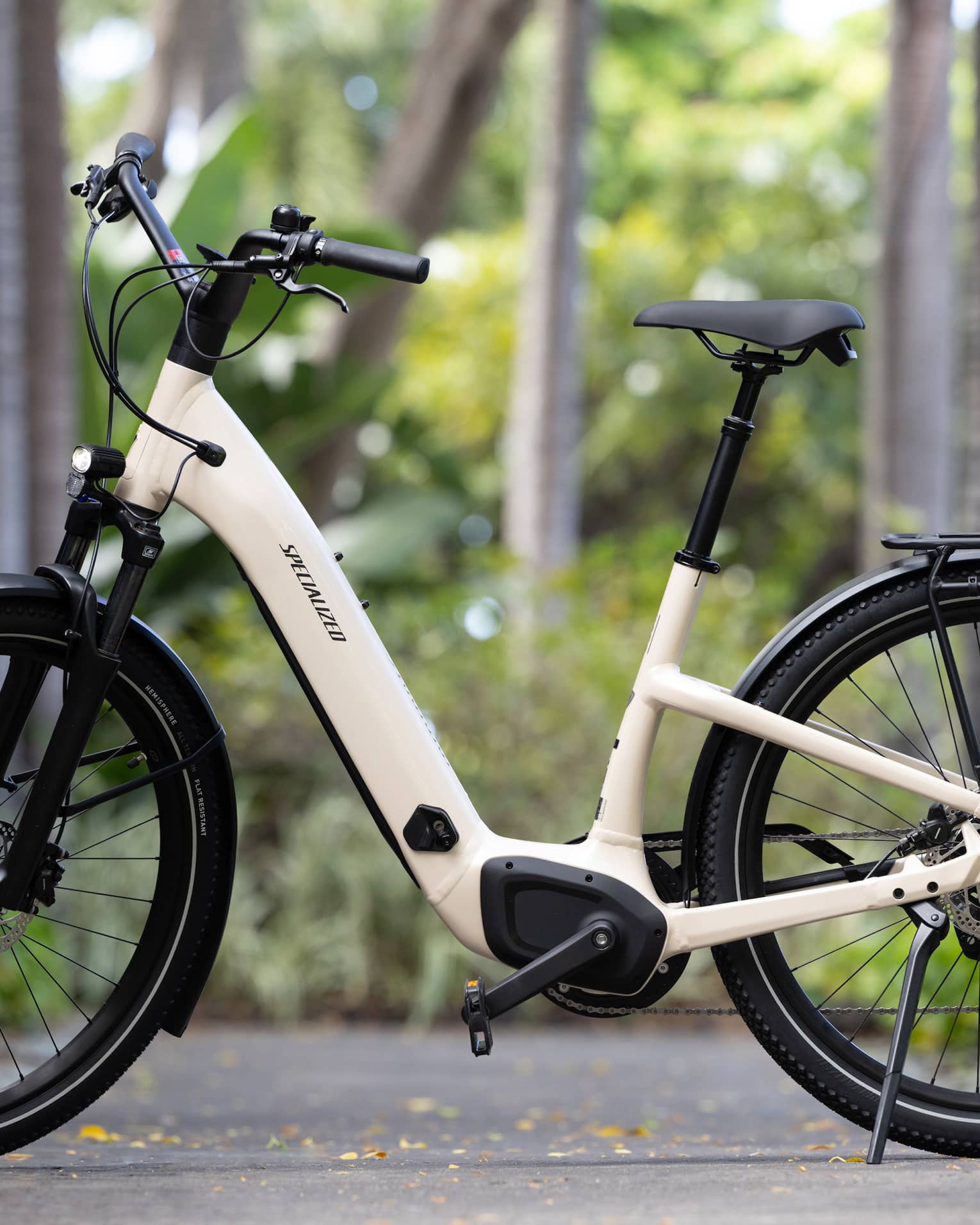 A stationary e-bike on a sidewalk with trees in the background.