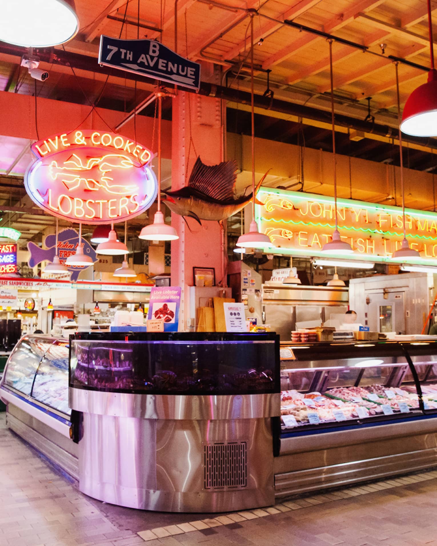 A large indoor market featuring fresh seafood behind glass windows.