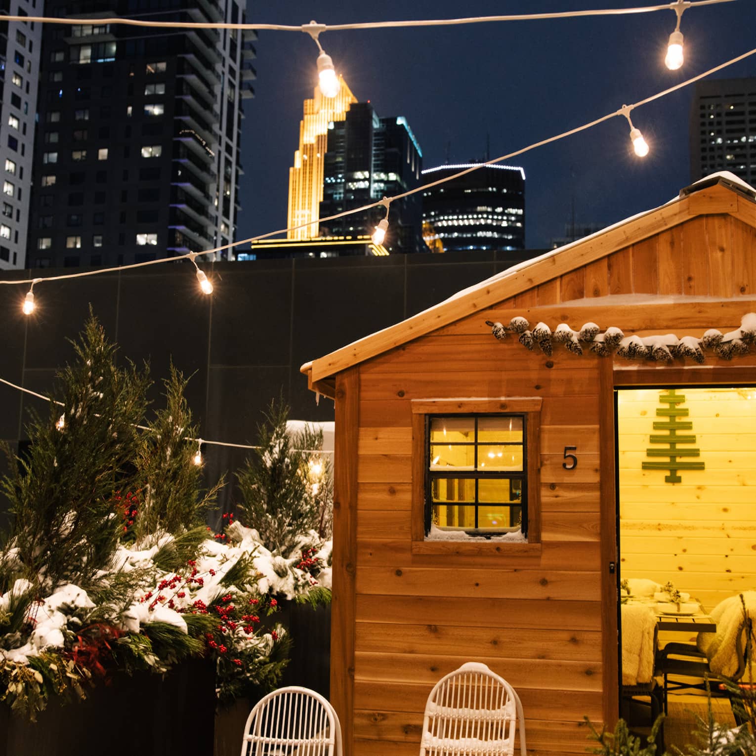 Nordic village on a city terrace with small cabins and string lights