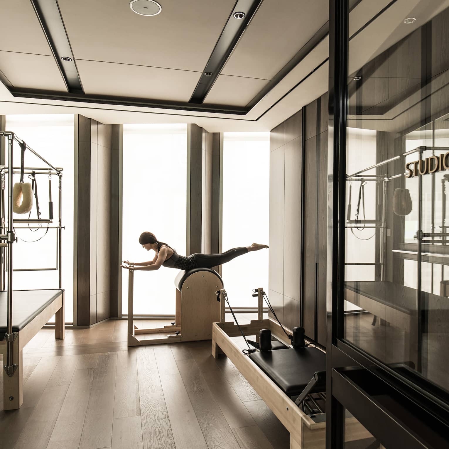 Woman stretches, balances on machine in Fitness Centre near weight station