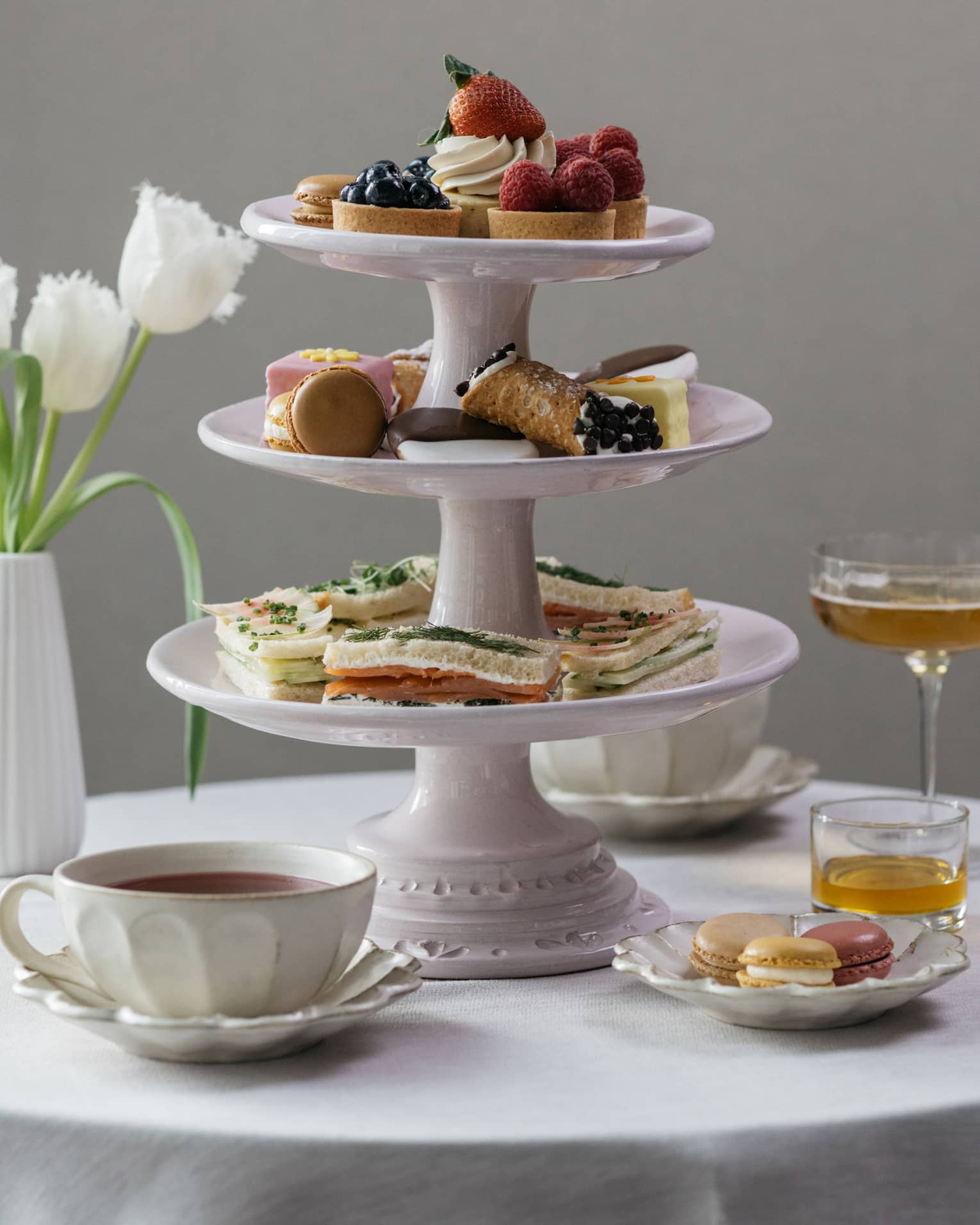 Afternoon tea setting, three-tiered dessert tray, tulips in vase, martinis and tea cups
