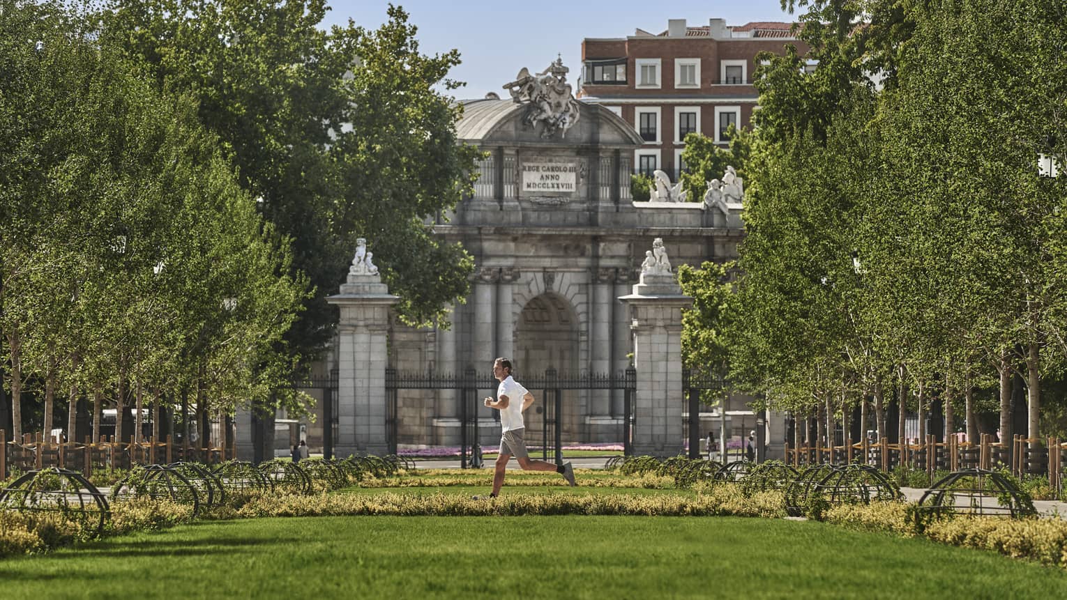 Man running in park passing historic buildings