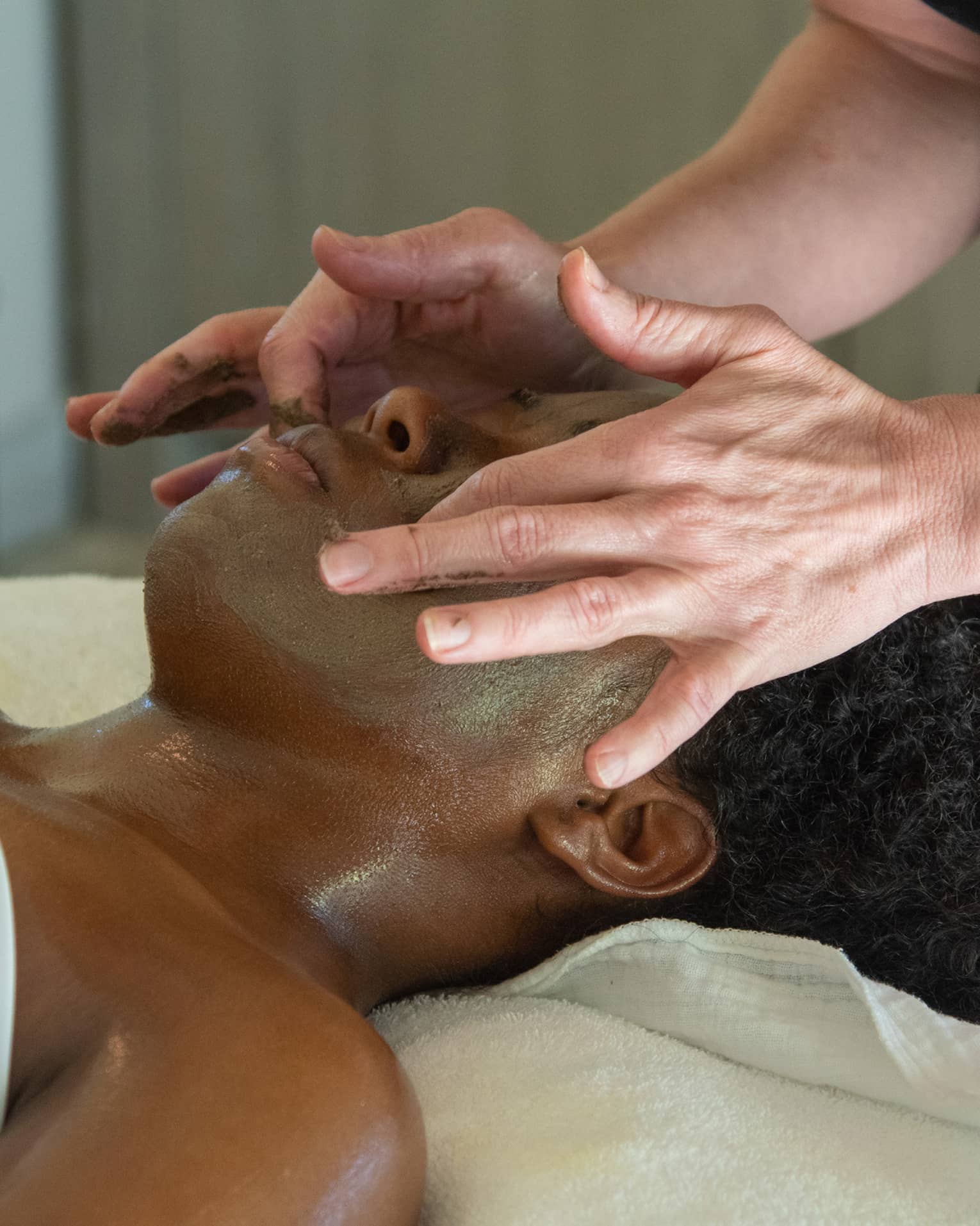 A woman receiving a facial massage.