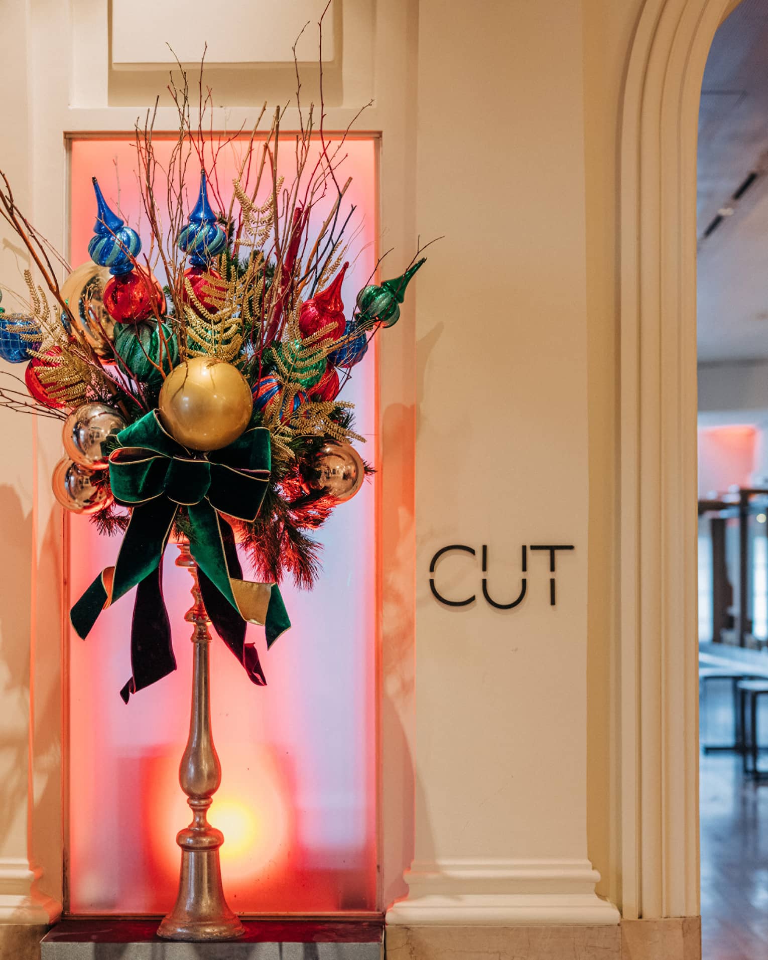 Festive floral arrangement with ornaments at entrance to luxury restaurant