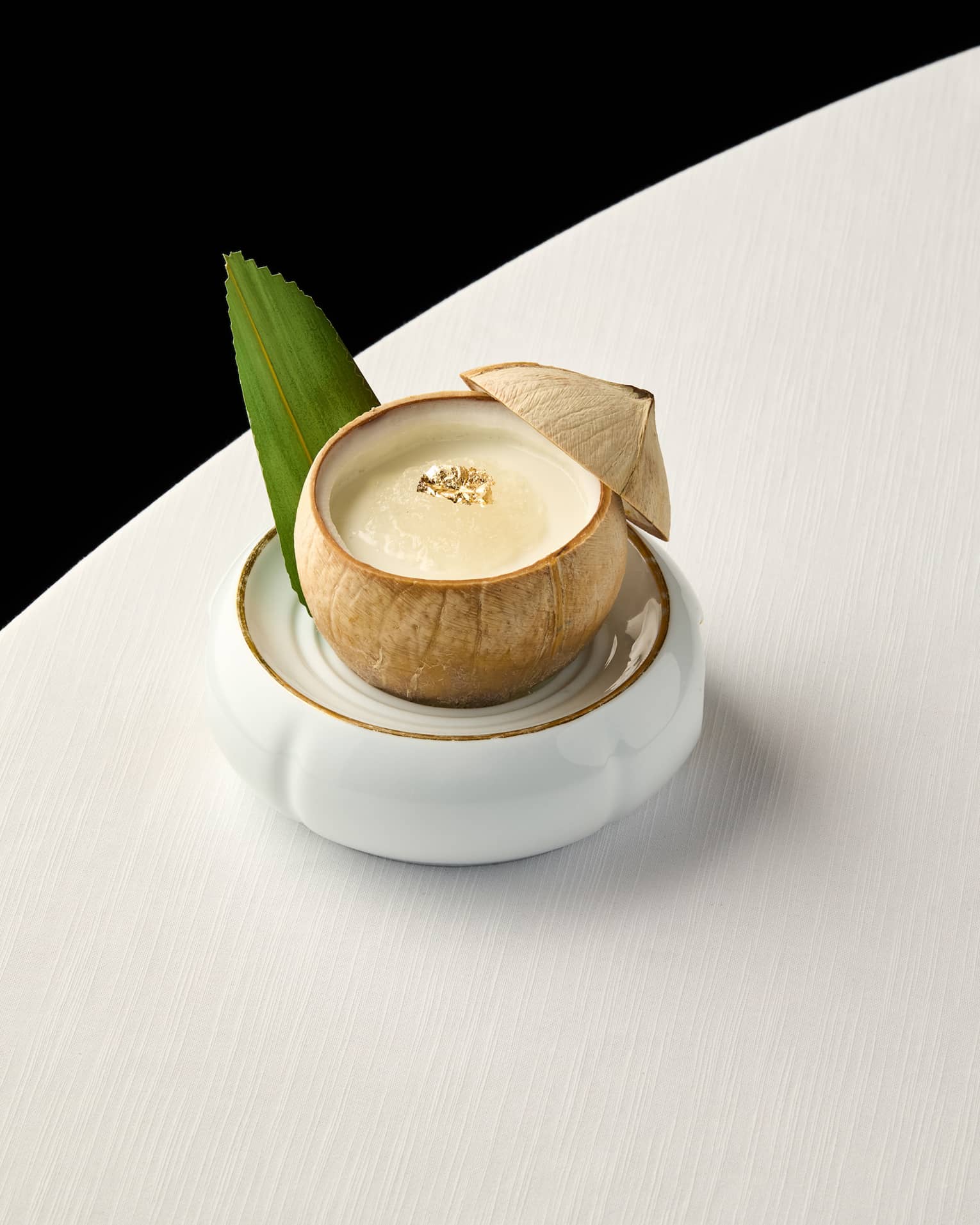 Pina Colada cocktail in a coconut on a white table