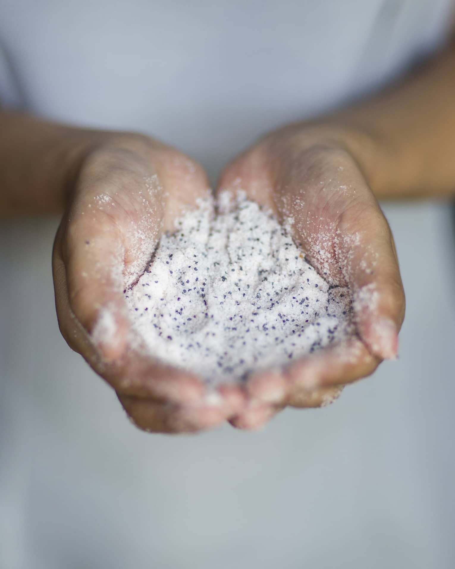 A woman holding sand in her hands.