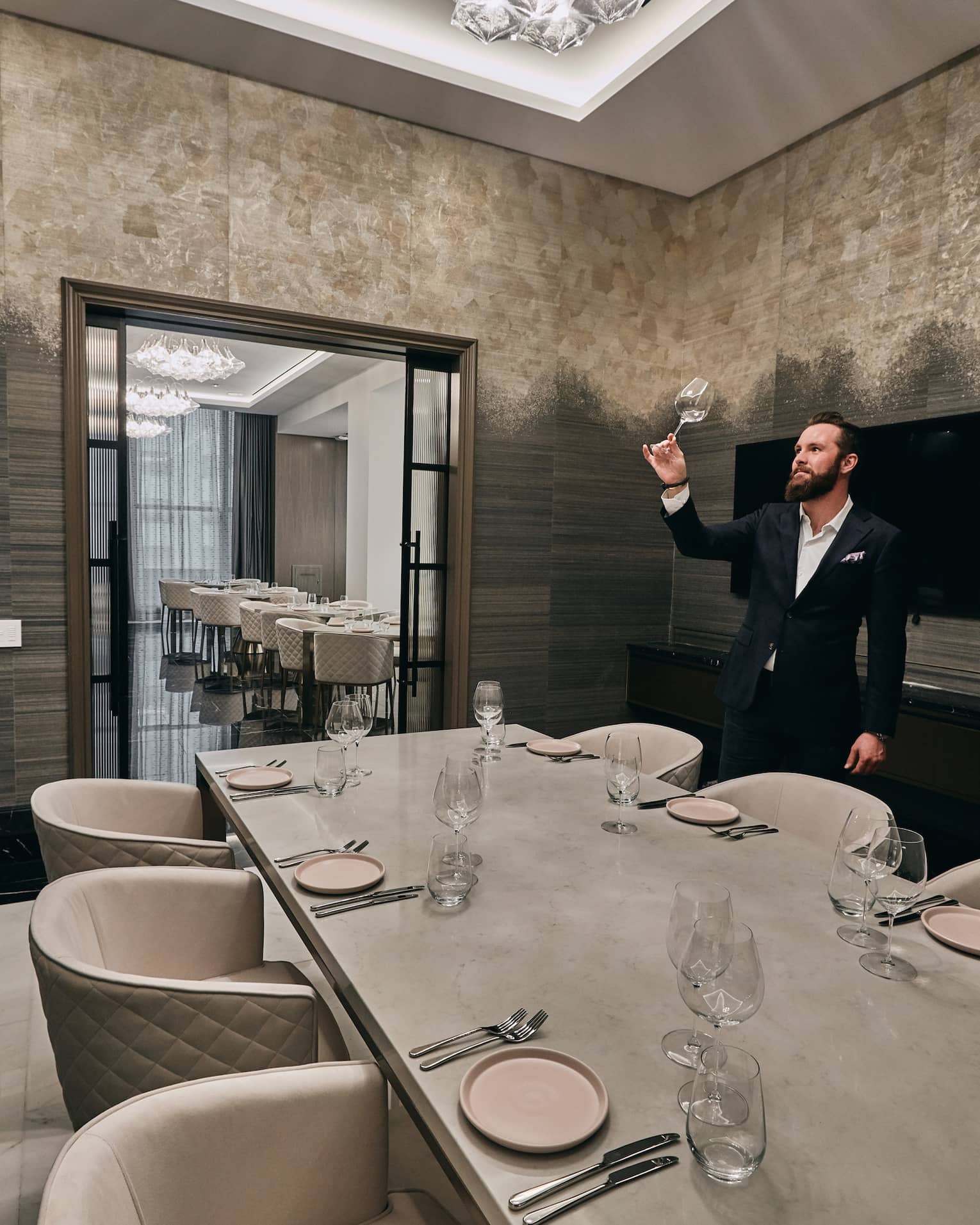 A private dining room with a six person table and a Sommelier looking at a glass of wine.