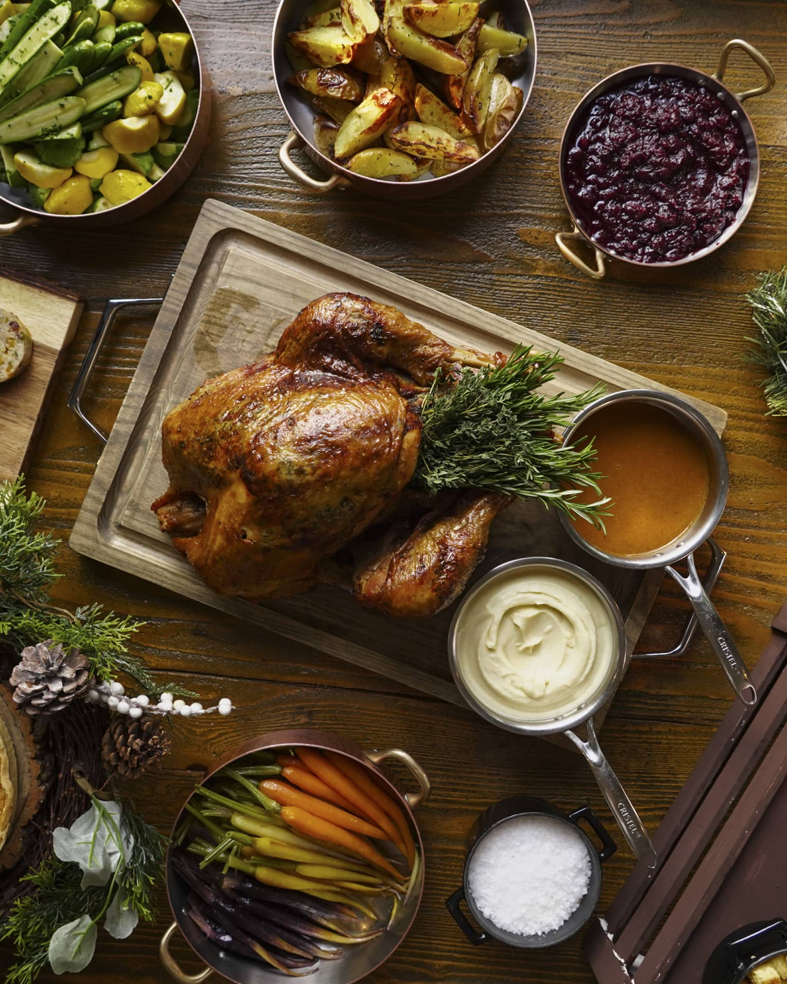 A full festive feast with a Turkey in the centre, and several copper pots of stewed vegetables surrounding
