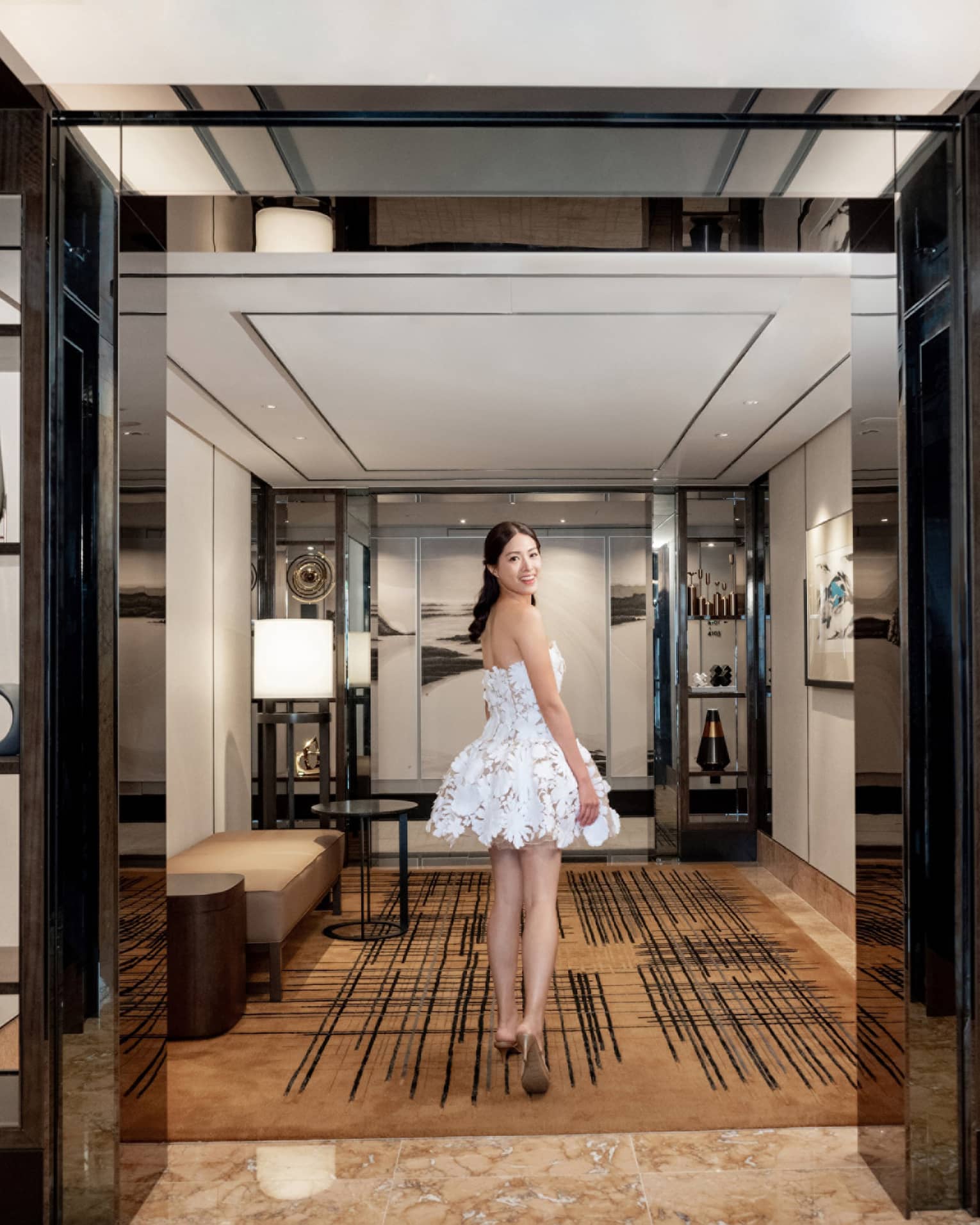Woman looks back as she walks through hotel suite