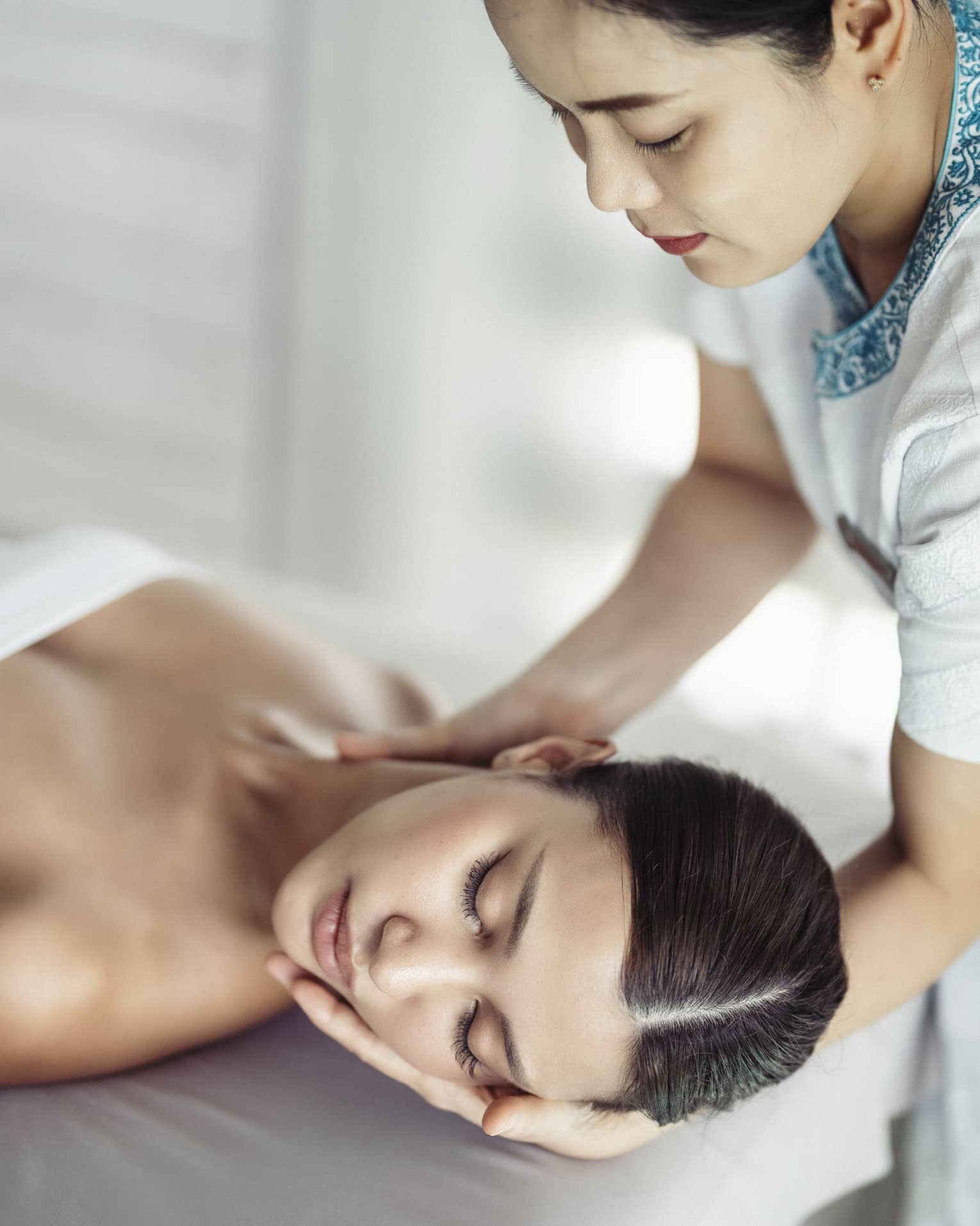 A woman in a spa receiving chiropracty.