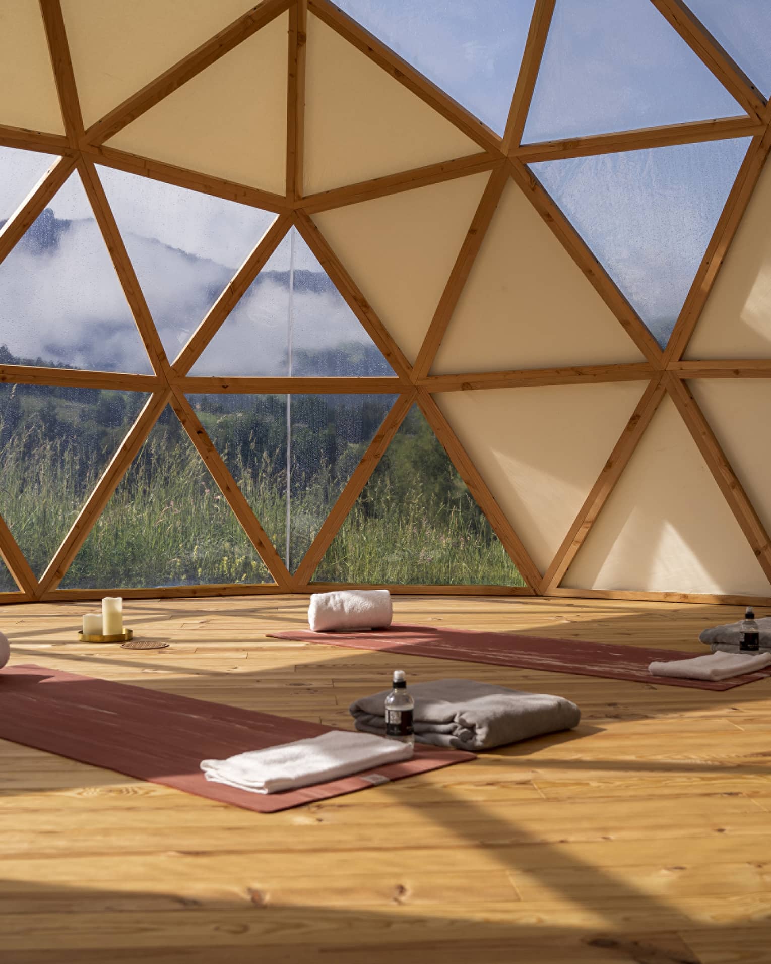 Spa studio set with two yoga mats and mountain view outside hive-like windows