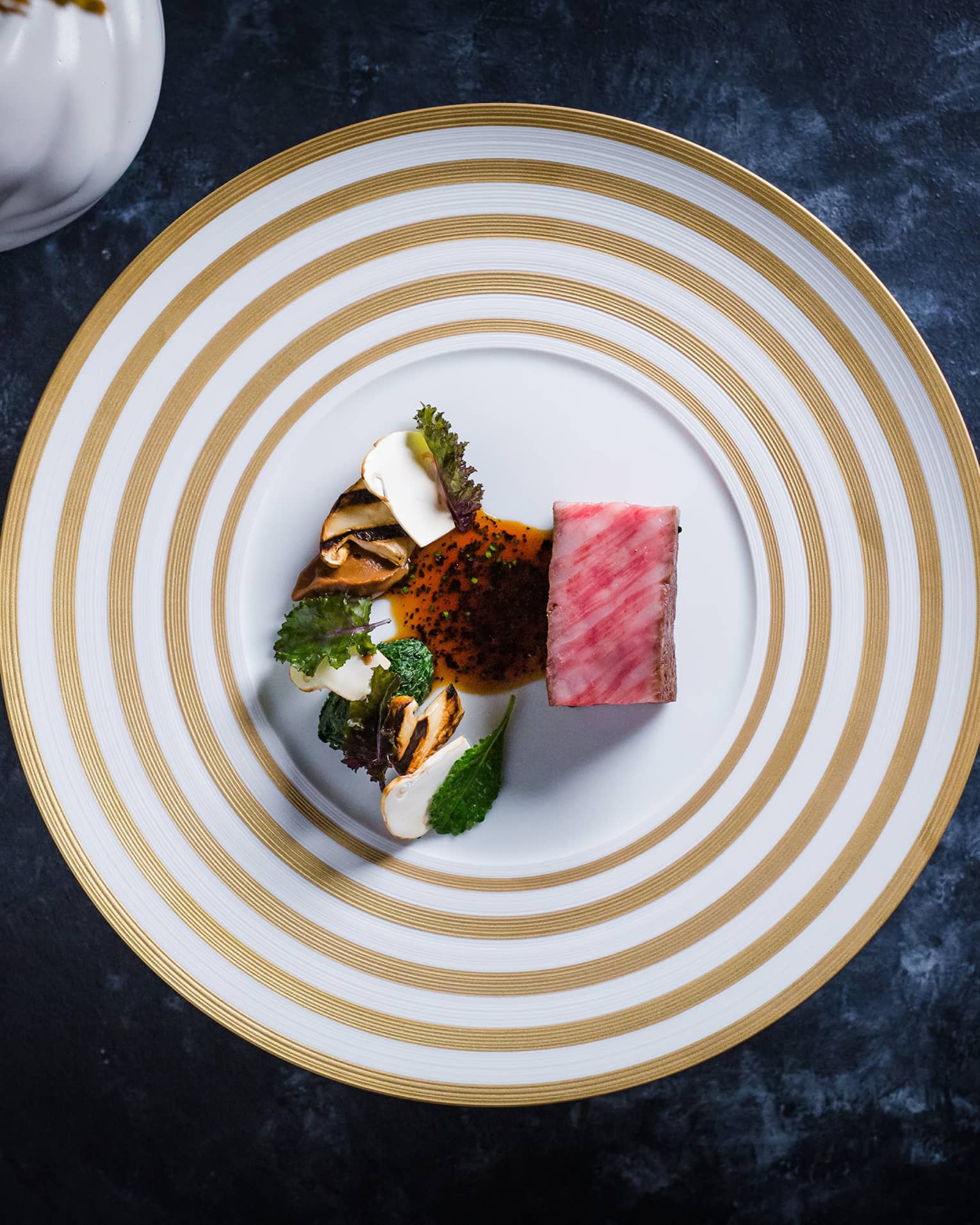 Colourful food on a white and beige plate.