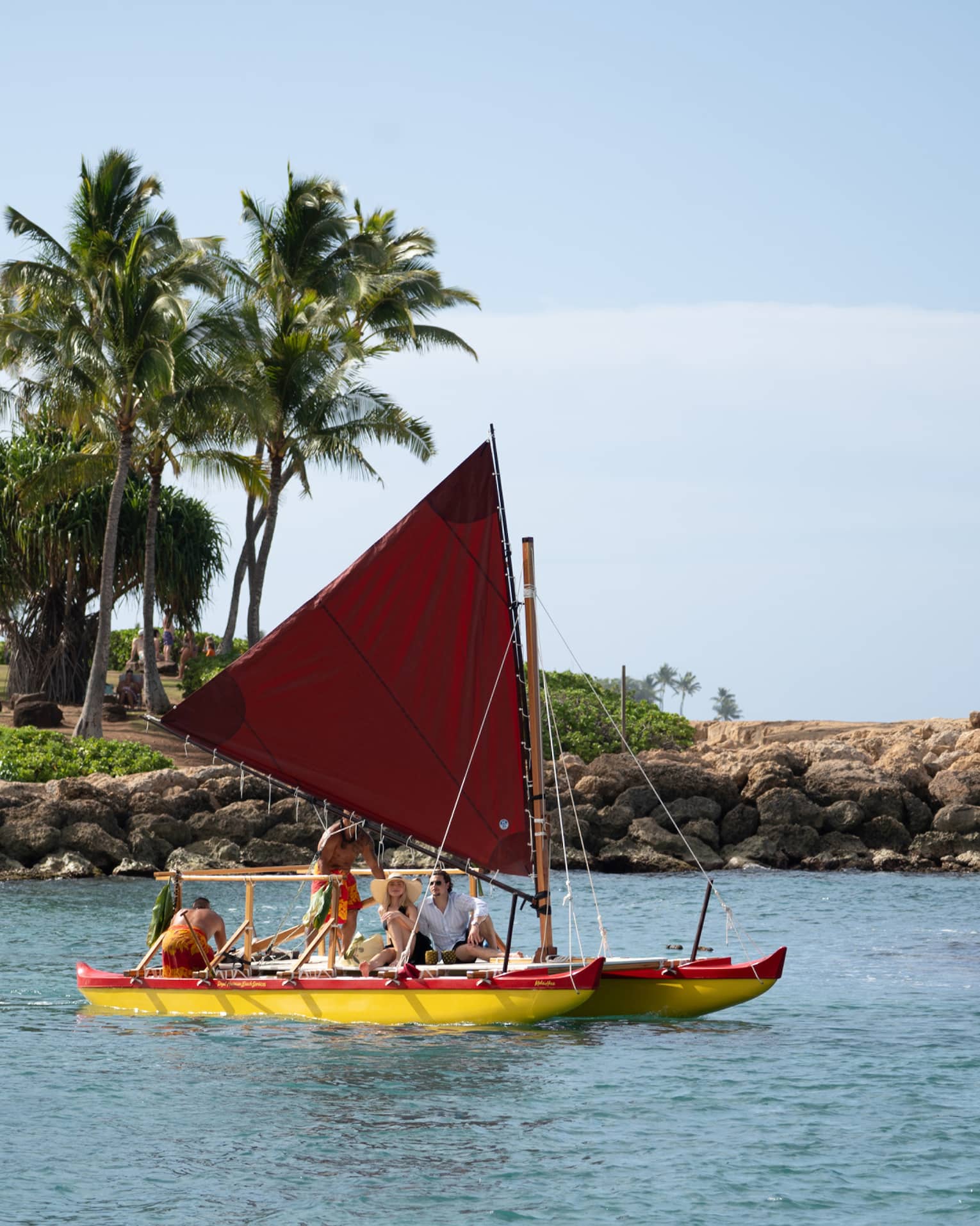 People sail in a traditional Hawaiian canoe in a lagoon