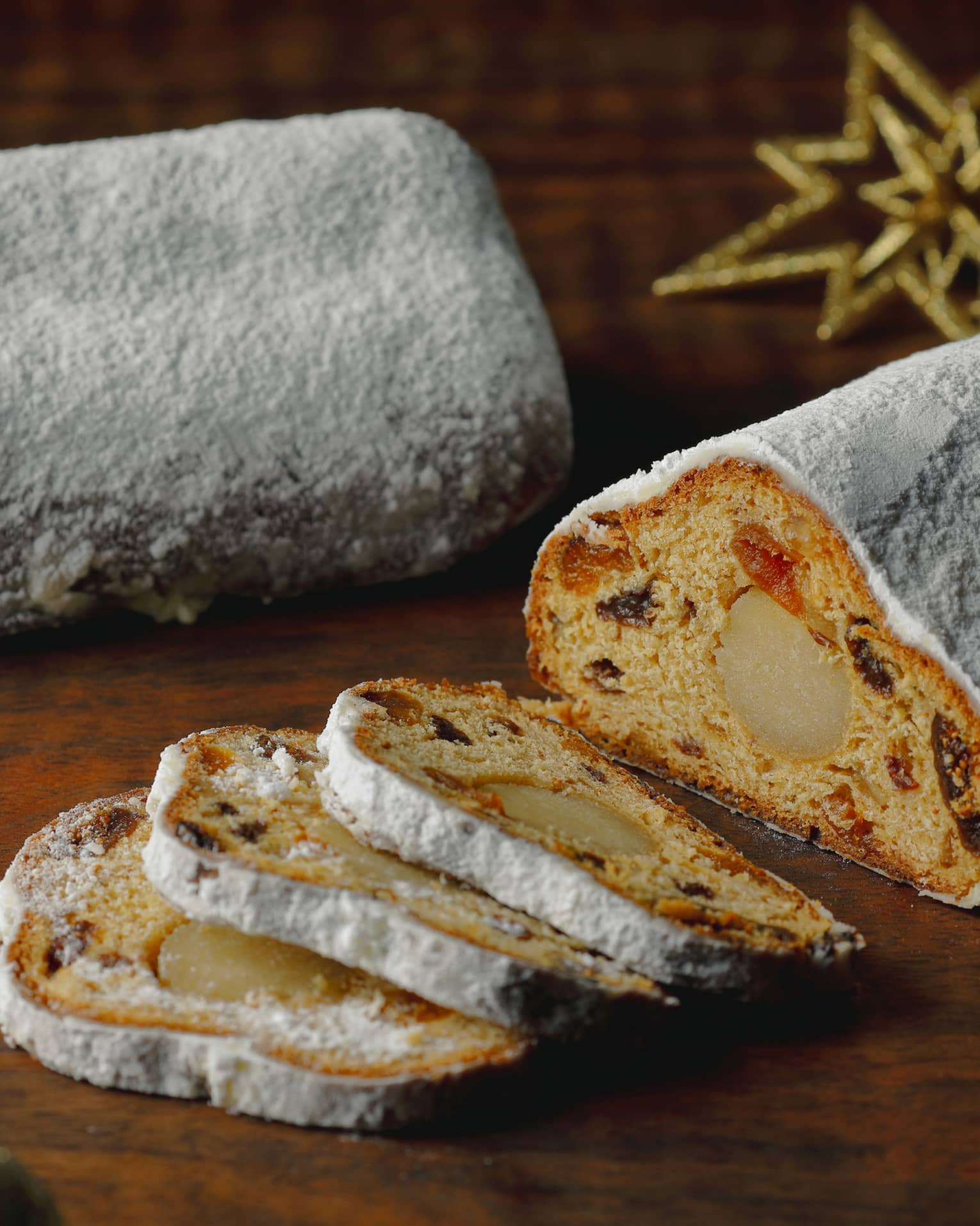 Stollen, sliced on a wooden table with festive decor