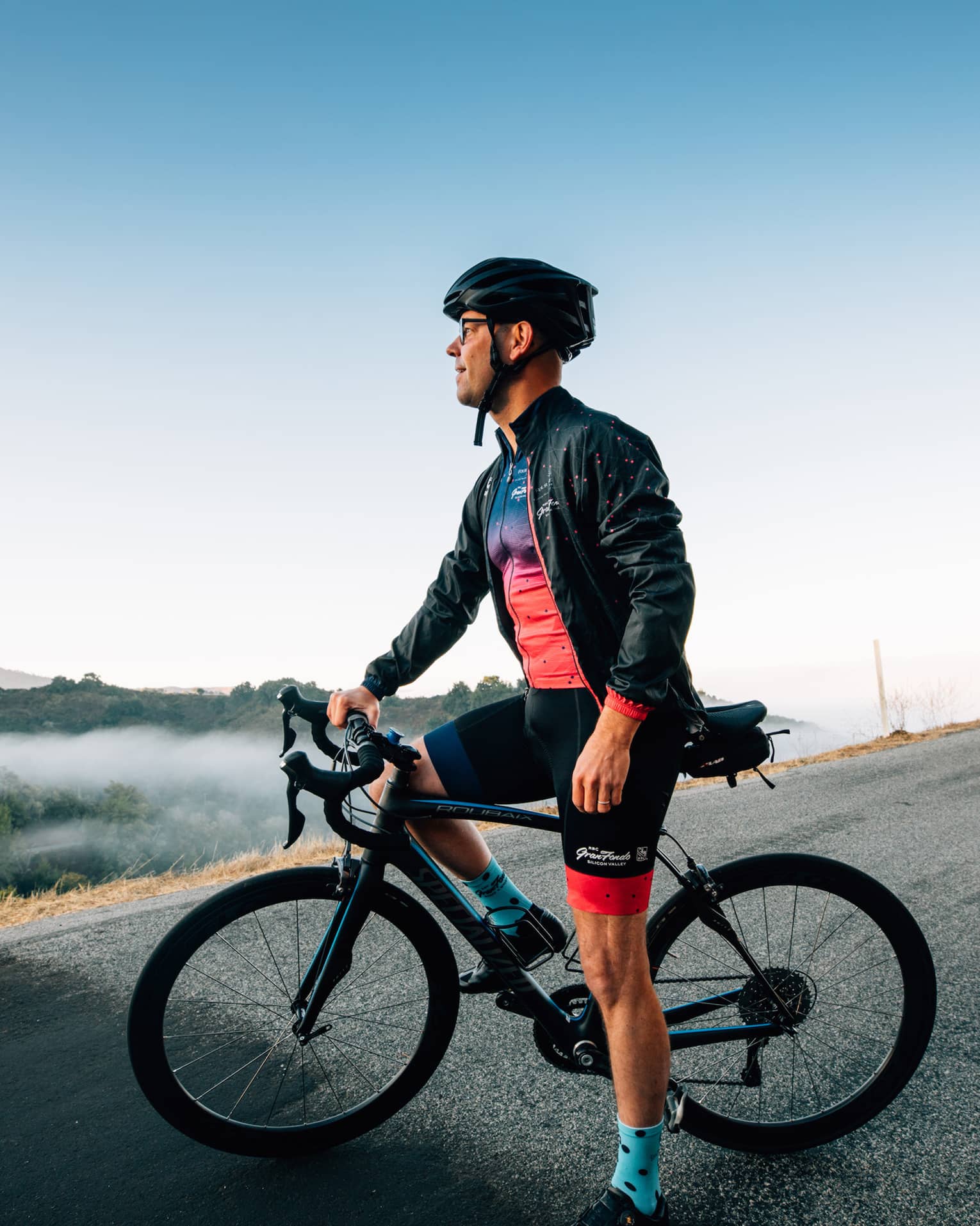 A male cyclist pauses to take in the mountainous surroundings.