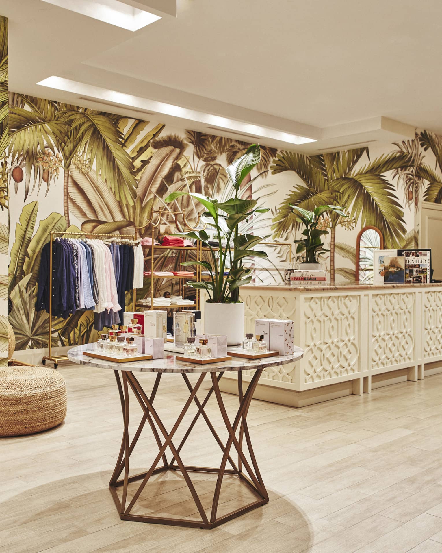 A brightly lit store with light wood features and clothes on shelves and hangers.