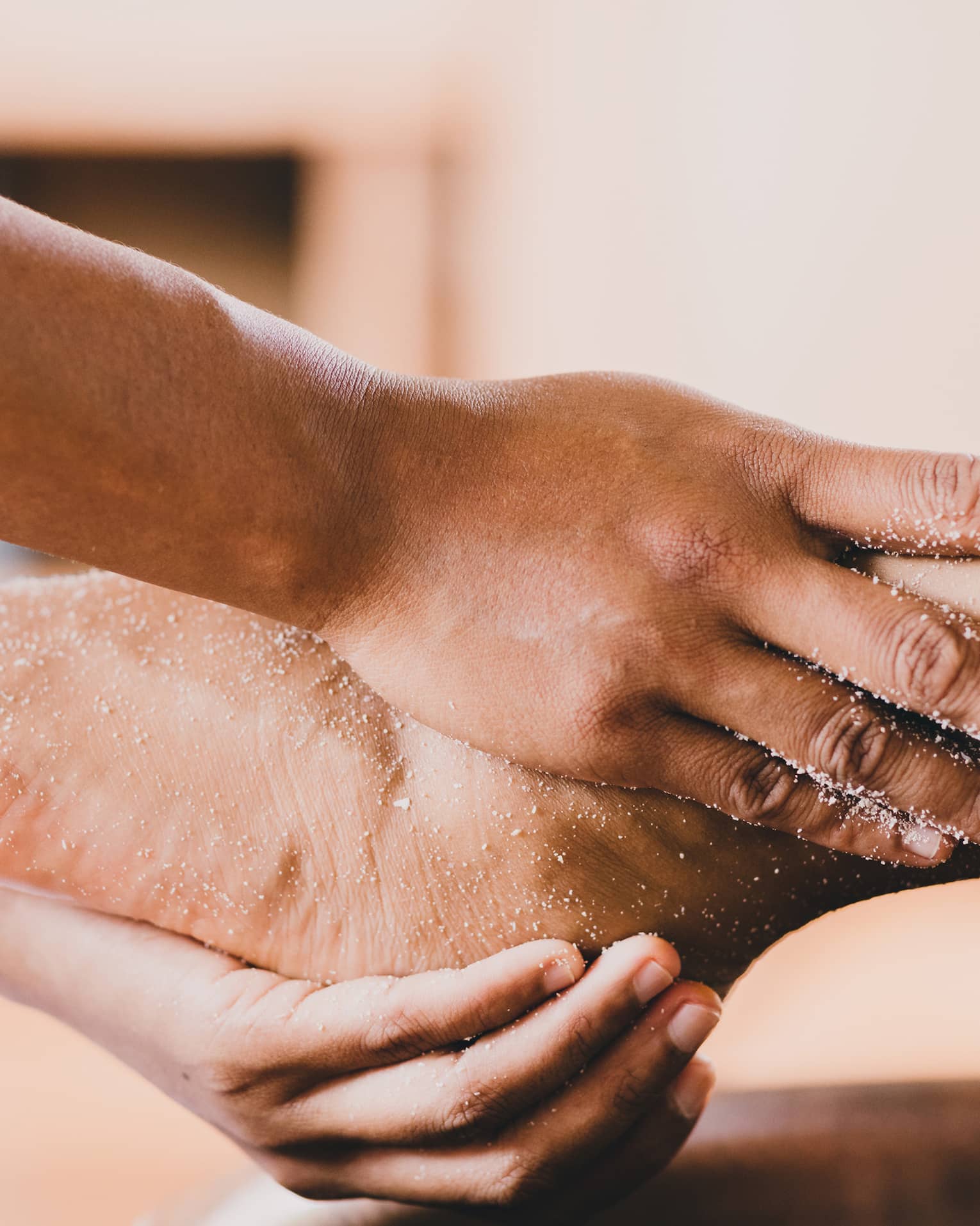Hands hold a person's foot and ankle in a spa