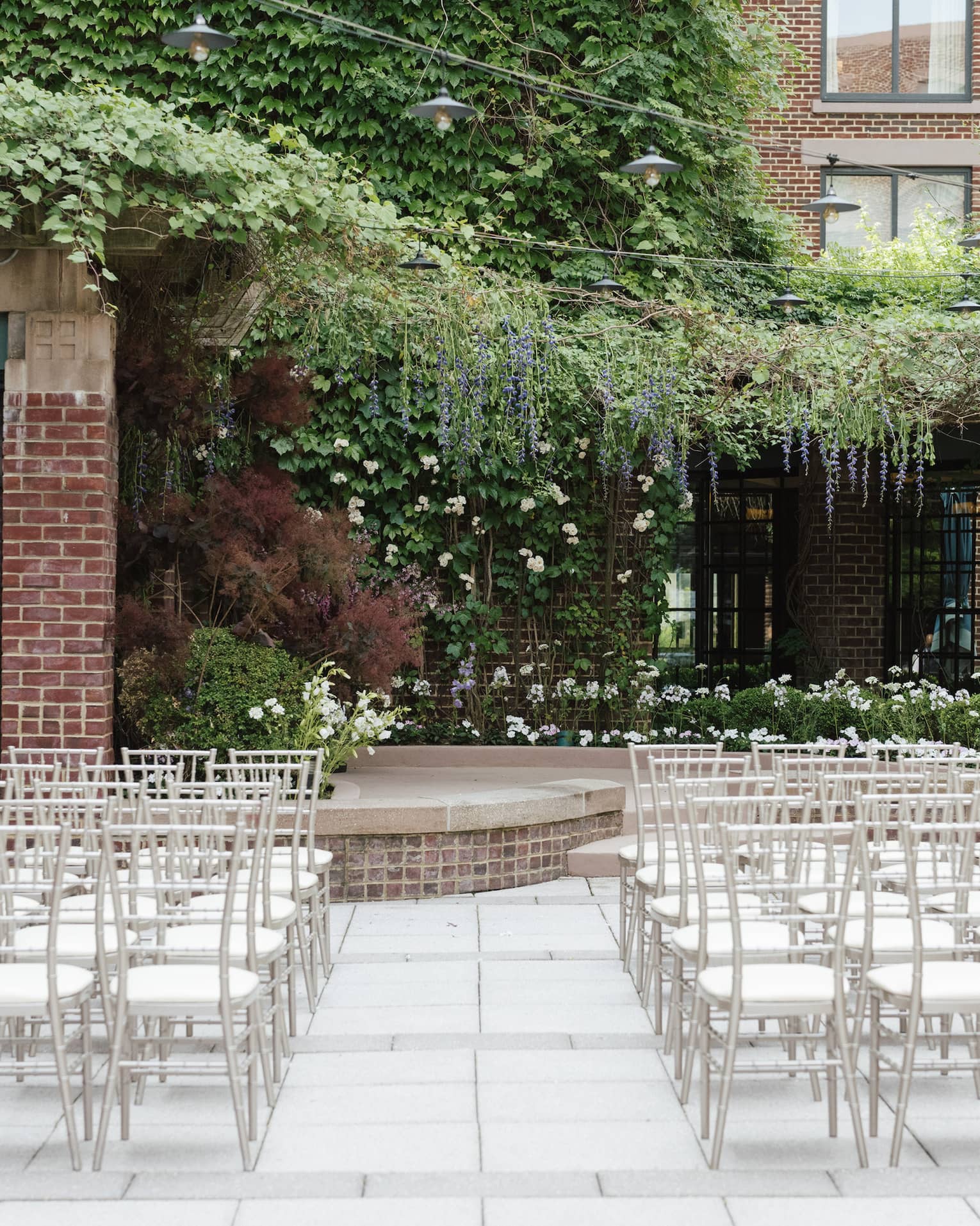 An outdoor venue with rows of white seats and greenery.