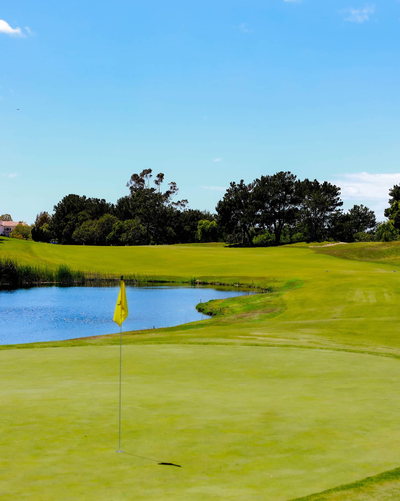 A golf course with a putting green and lake