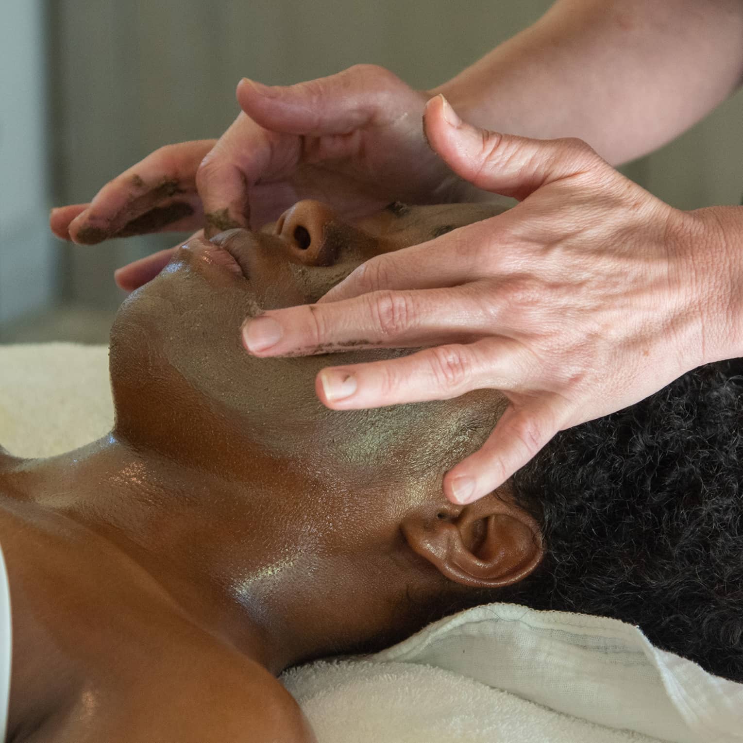 A woman receiving a facial massage.