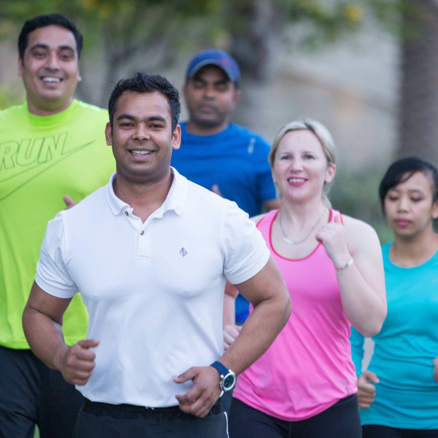 Group of six people wearing workout clothing, jogging