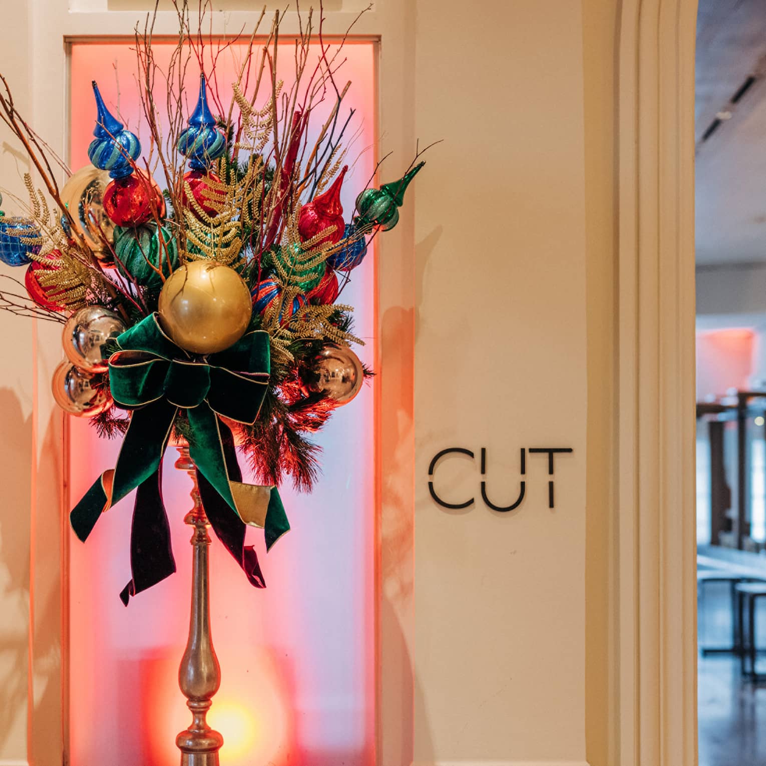 Festive floral arrangement with ornaments at entrance to luxury restaurant