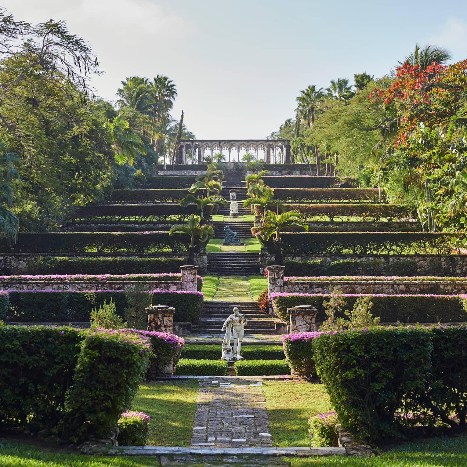 Statues on steps of hedges, manicured gardens 