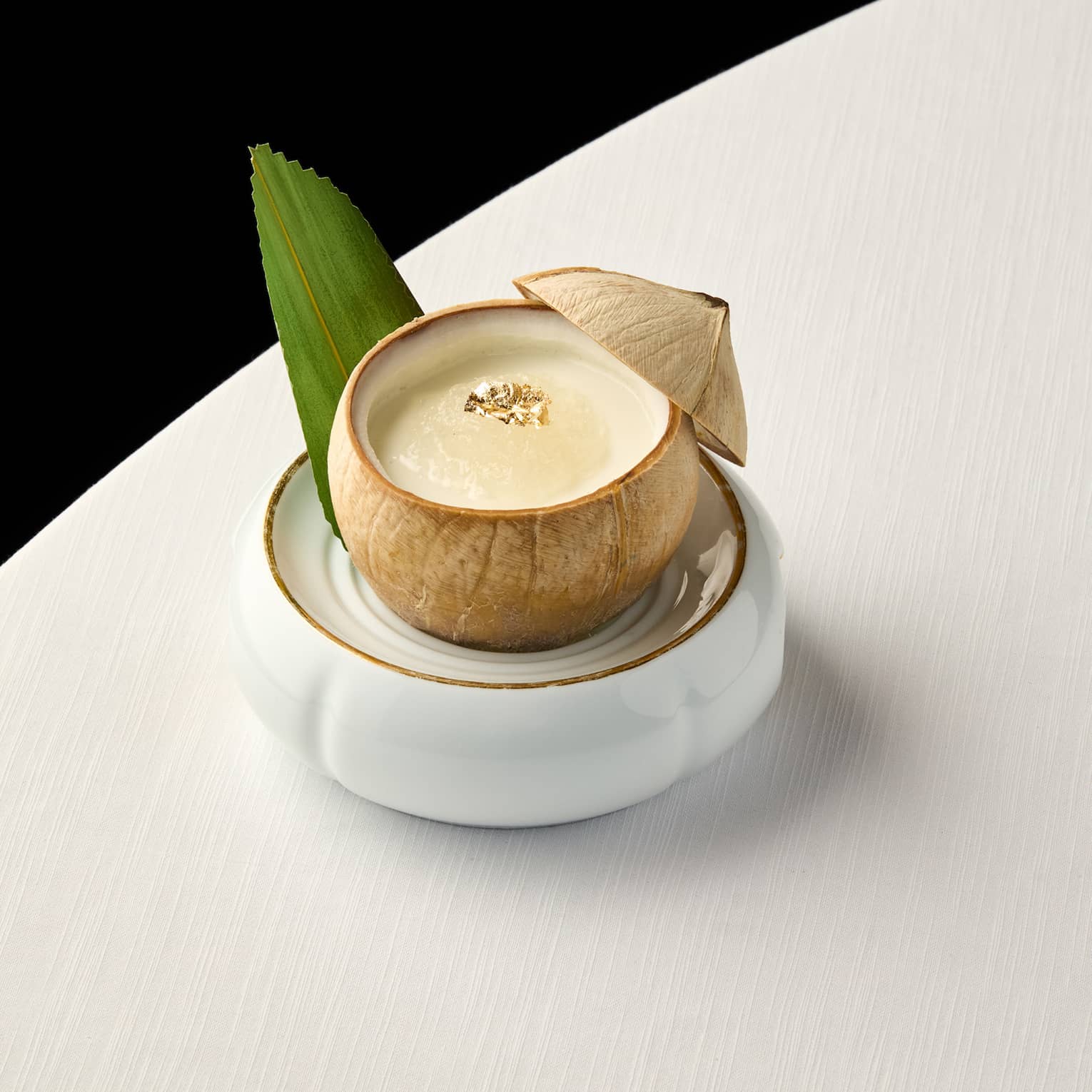 Pina Colada cocktail in a coconut on a white table