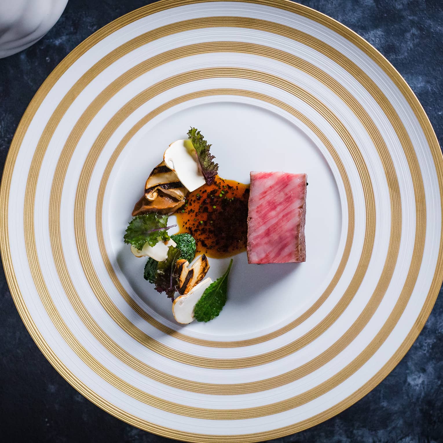 Colourful food on a white and beige plate.