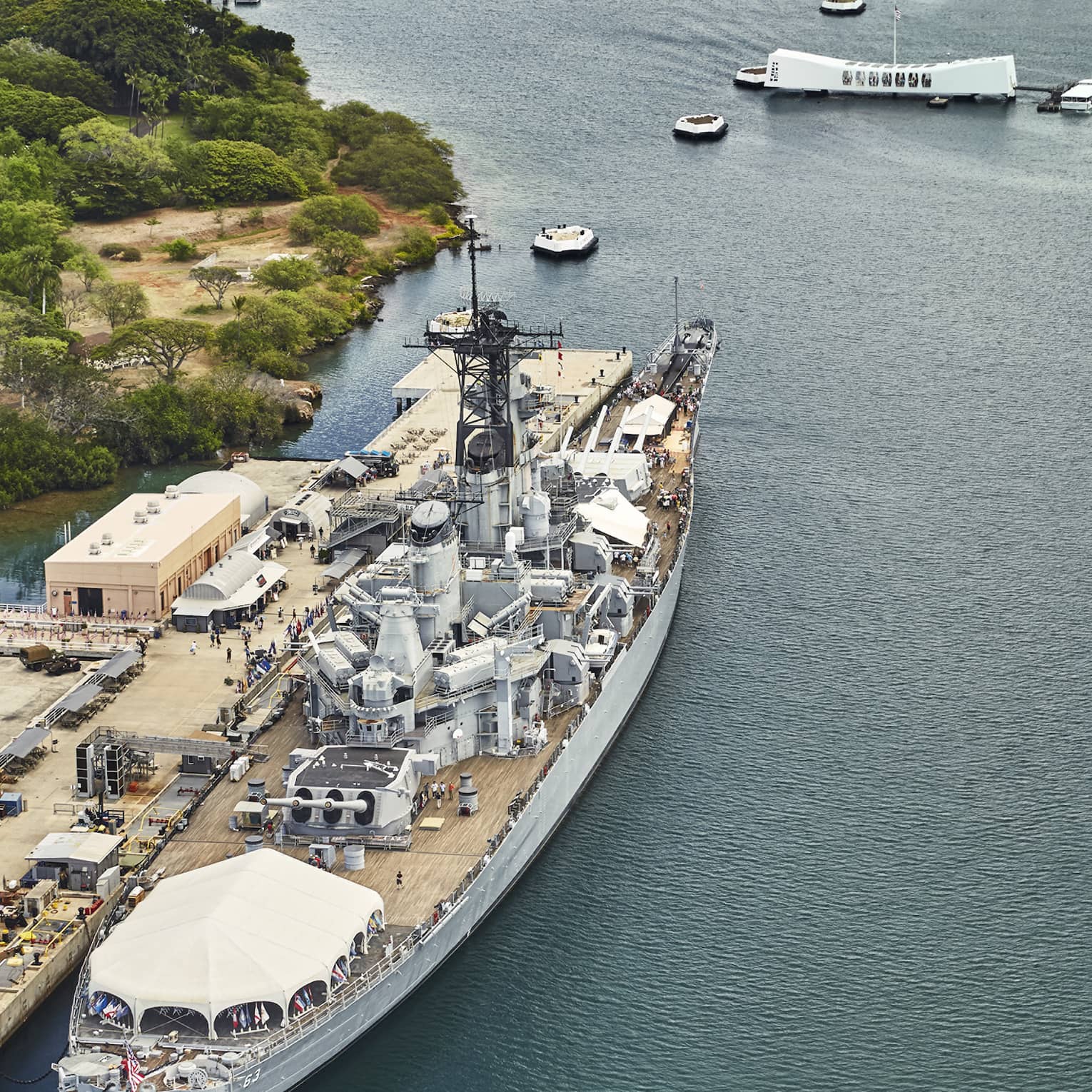 Aerial view of large battleship, people on dock at Battleship Missouri Memorial at Pearl Harbor