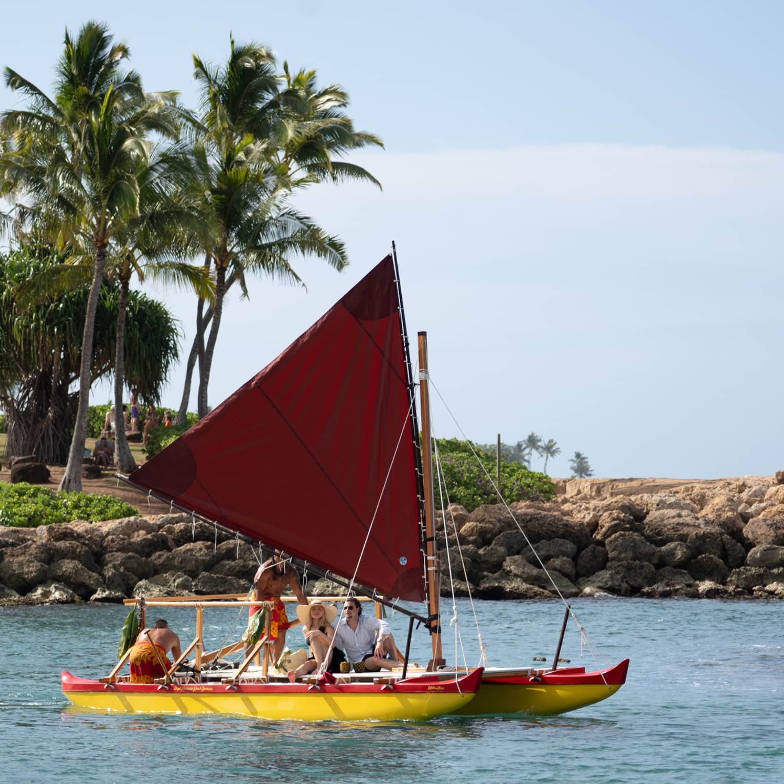 People sail in a traditional Hawaiian canoe in a lagoon