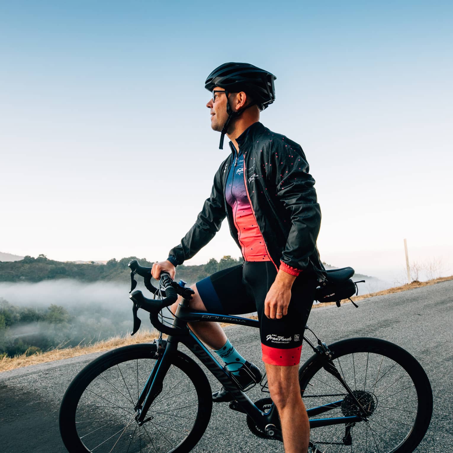 A male cyclist pauses to take in the mountainous surroundings.
