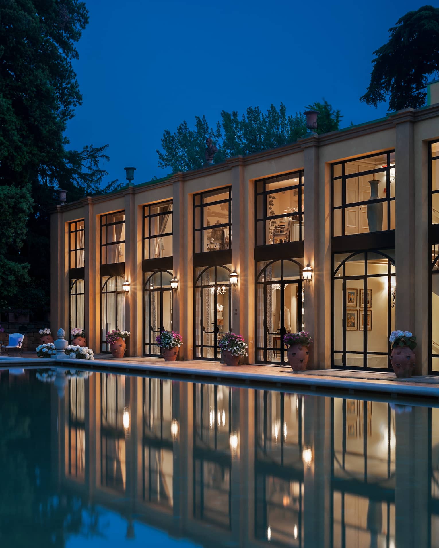 Four Seasons Hotel Florence two-level exterior with large picture windows overlooking pool at night