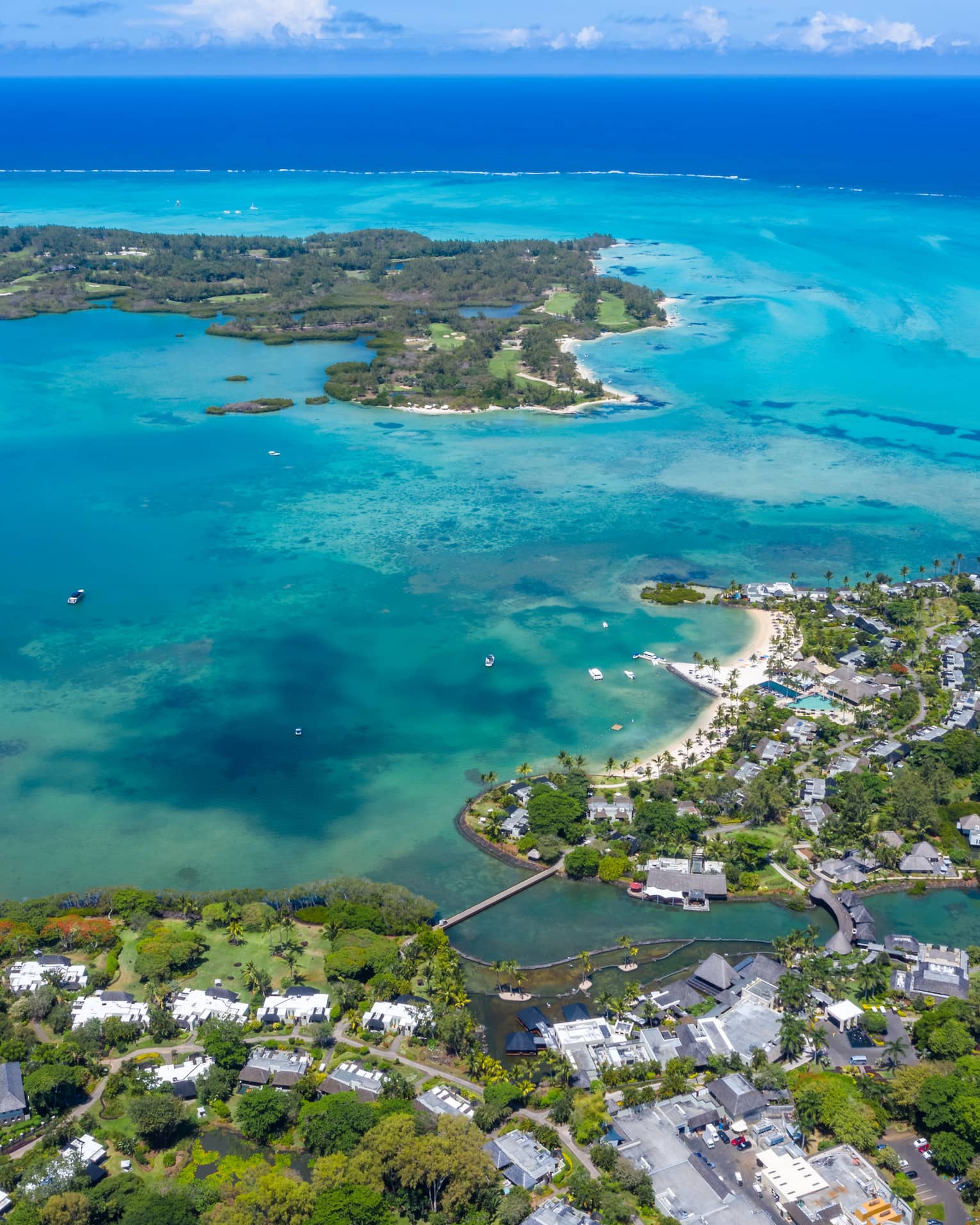 Aerial view of resort amid green tropical foliage and blue-green waters