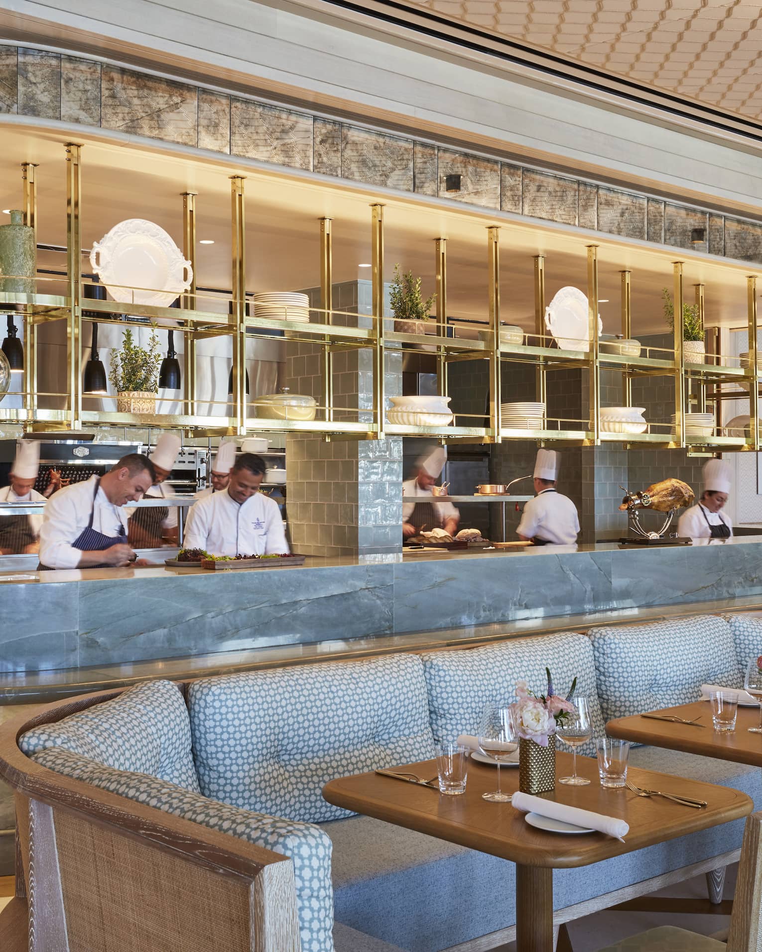 Staff members behind Flories curved blue marble bar, blue banquette seating
