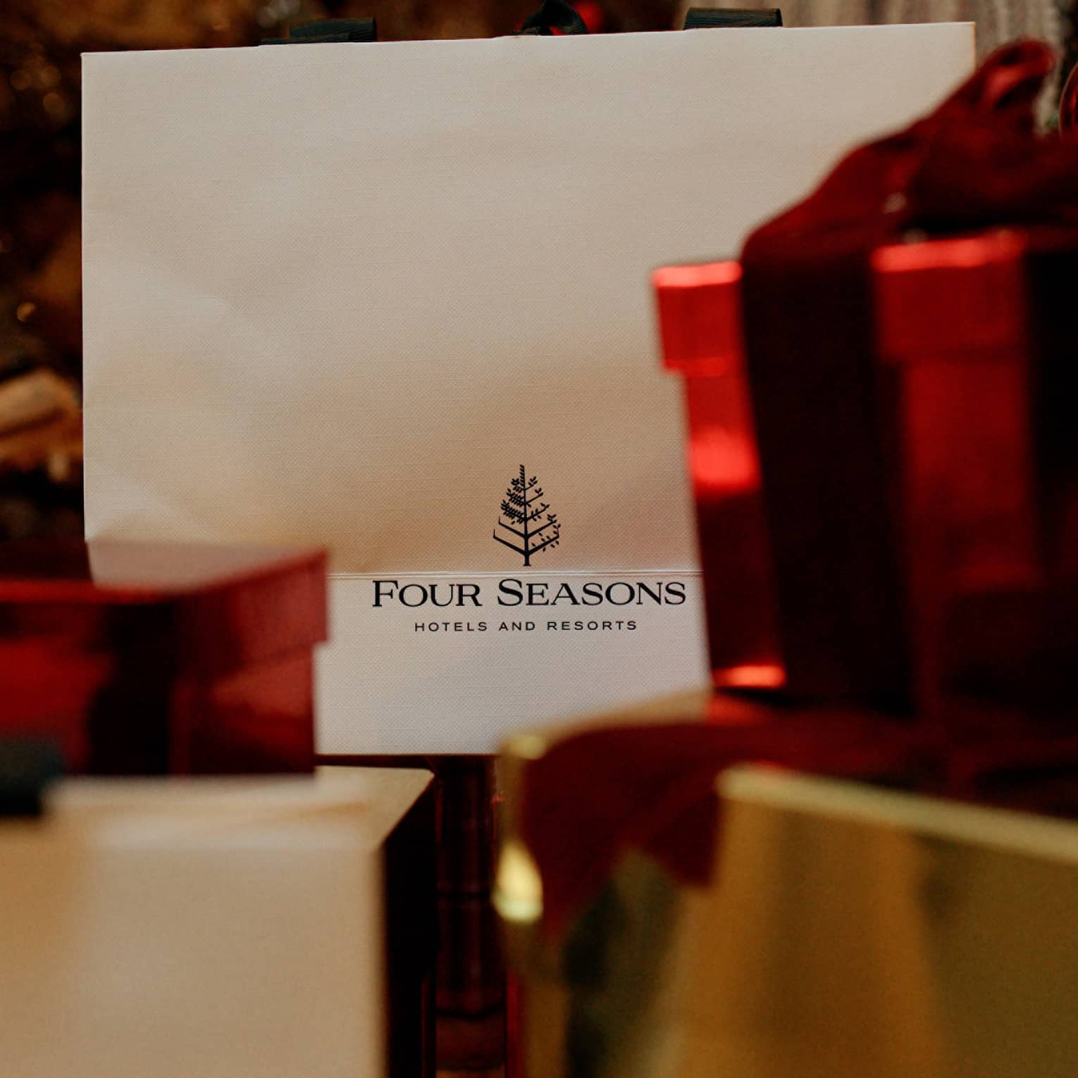 A gift card next to red and gold wrapped presents.