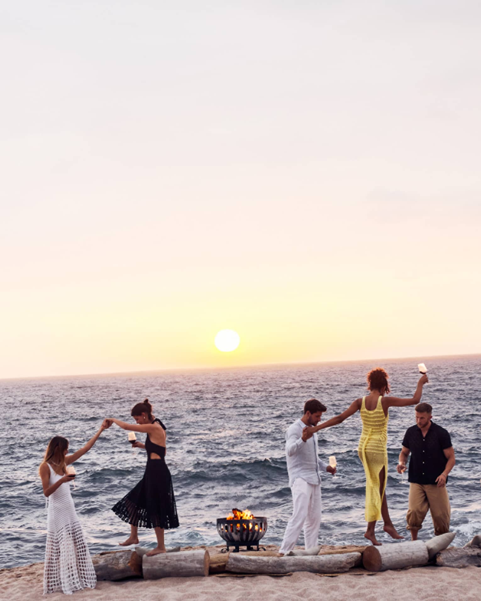 A group of people dancing on a beach.