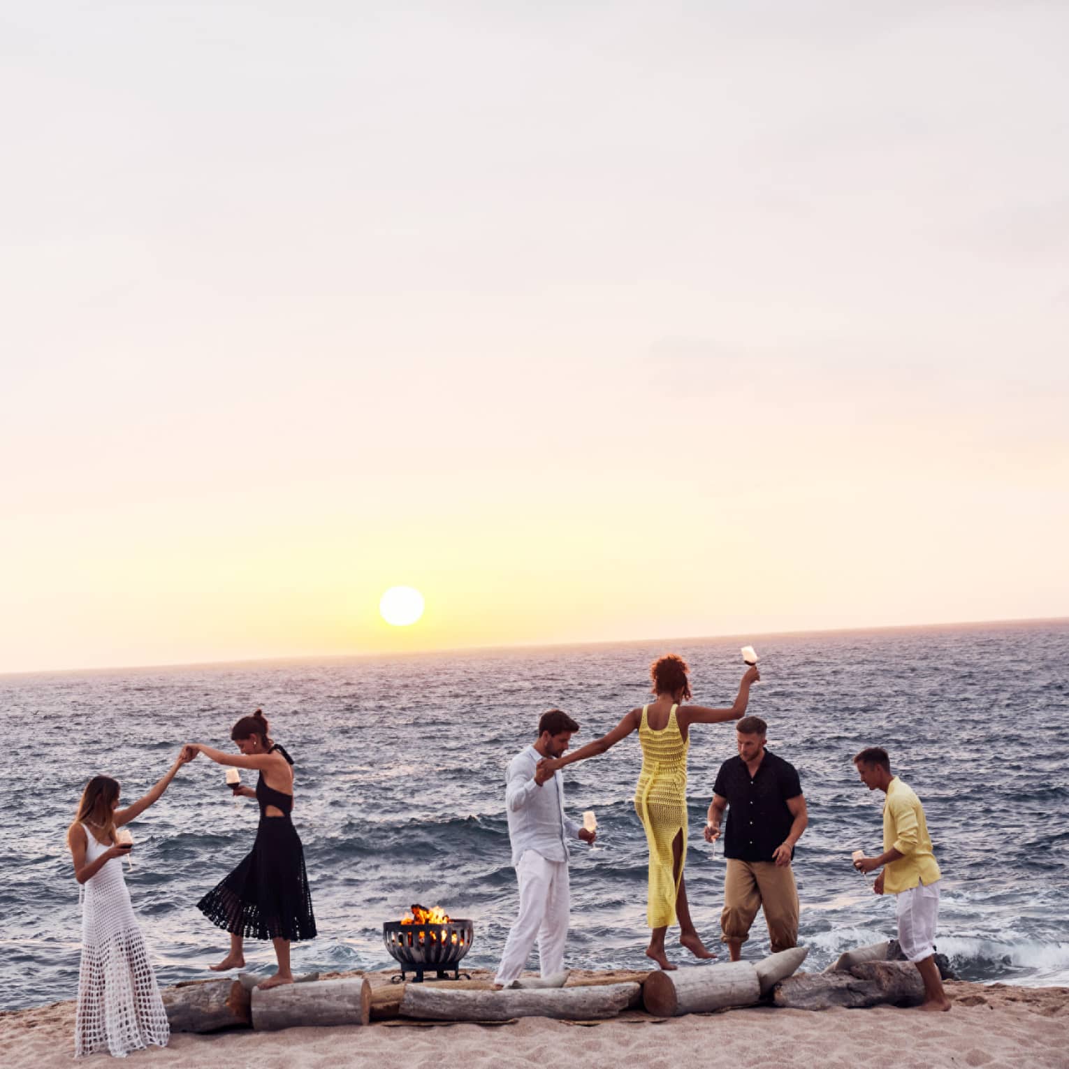 A group of people dancing on a beach.